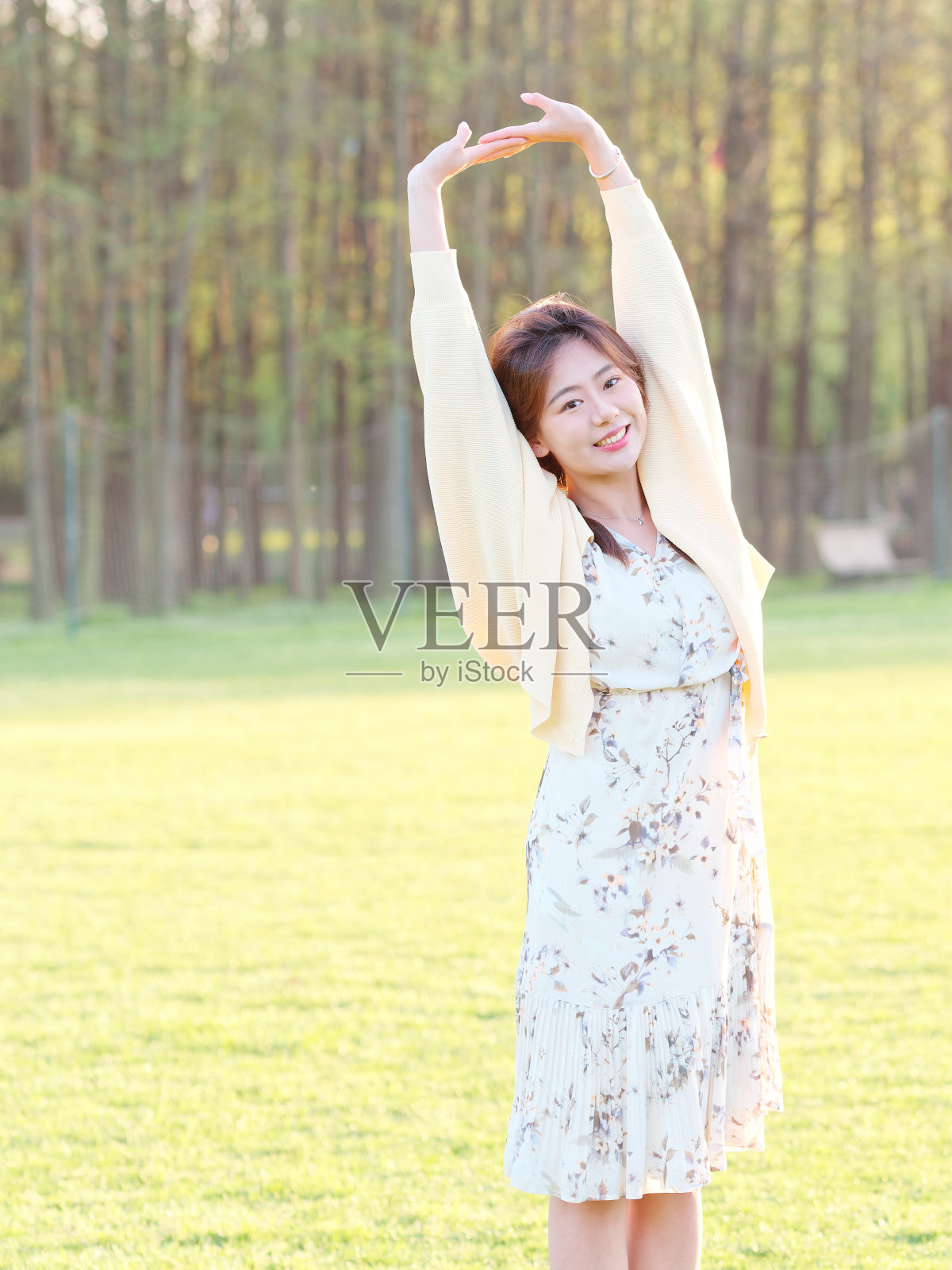 在阳光明媚的日子里，衣着优雅的中国女孩在森林公园里享受着悠闲的时光。户外时尚肖像魅力年轻的中国开朗的时尚女人。照片摄影图片