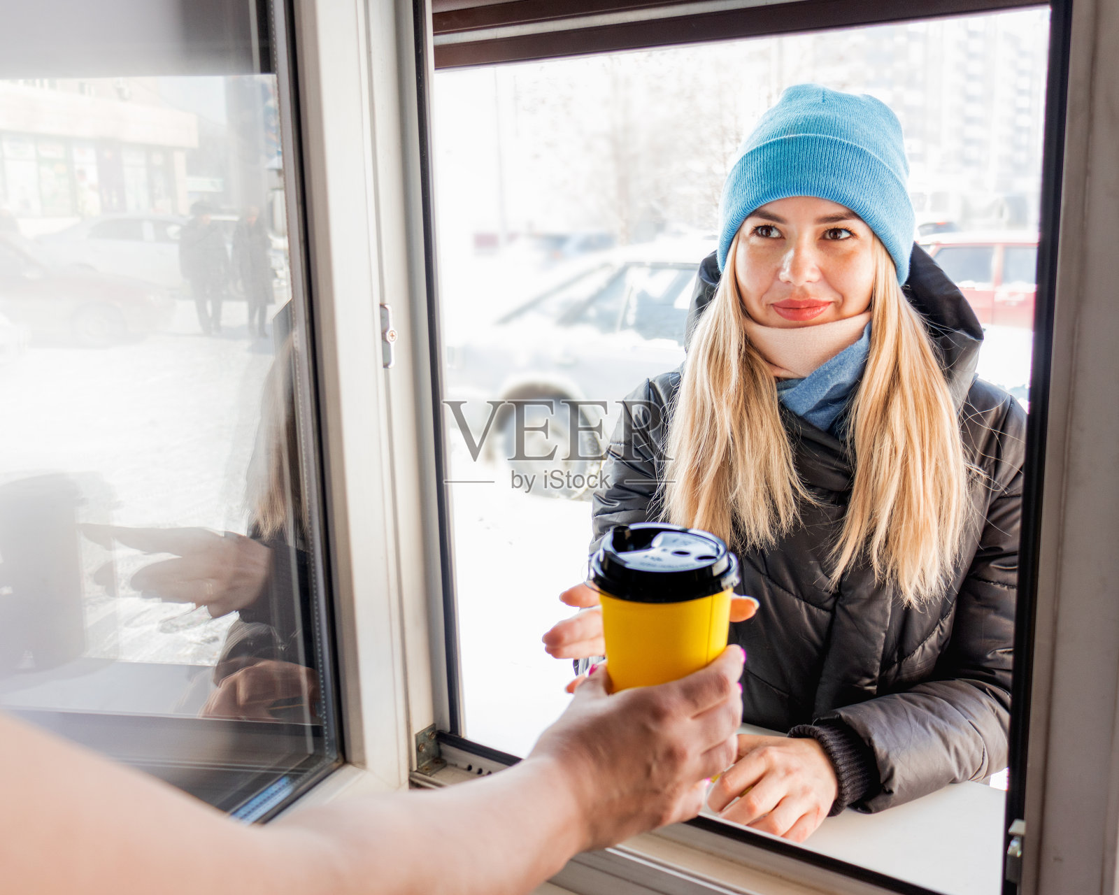 在买咖啡的时候，服务员正通过窗口为一位女士端上一杯咖啡。服务，客户服务，选择性专注，照片摄影图片