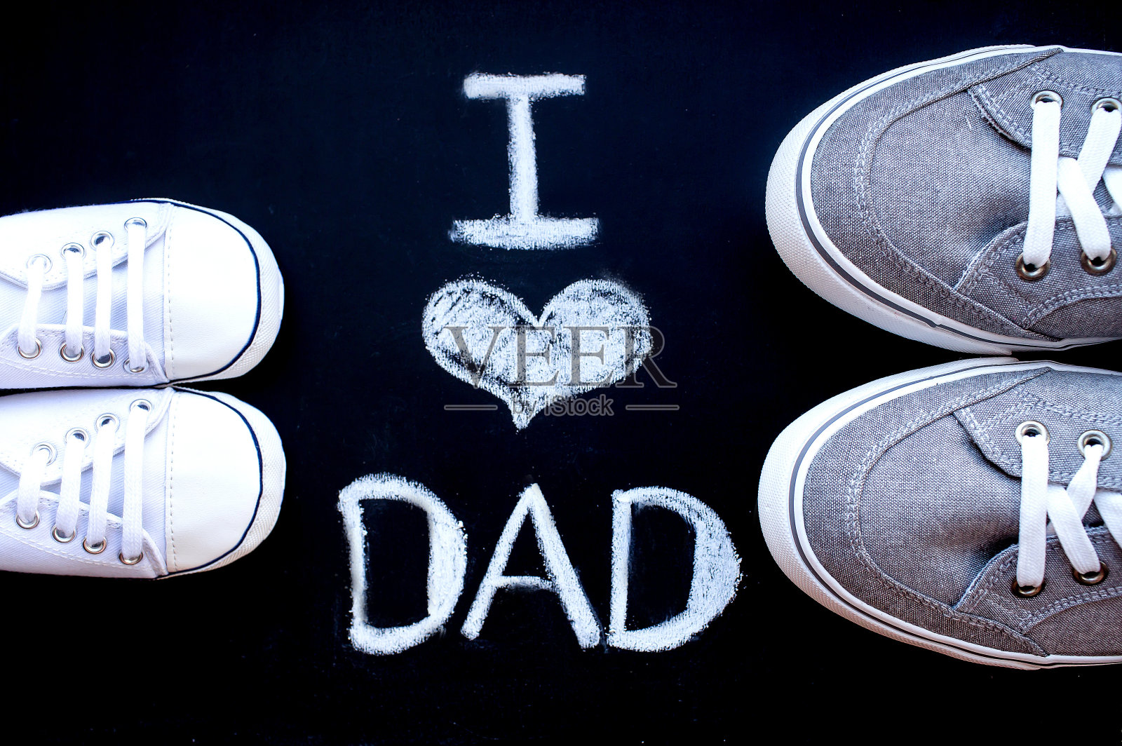 父子。父亲节这天，一双浅色运动鞋，黑色背景上写着“我爱爸爸”。照片摄影图片