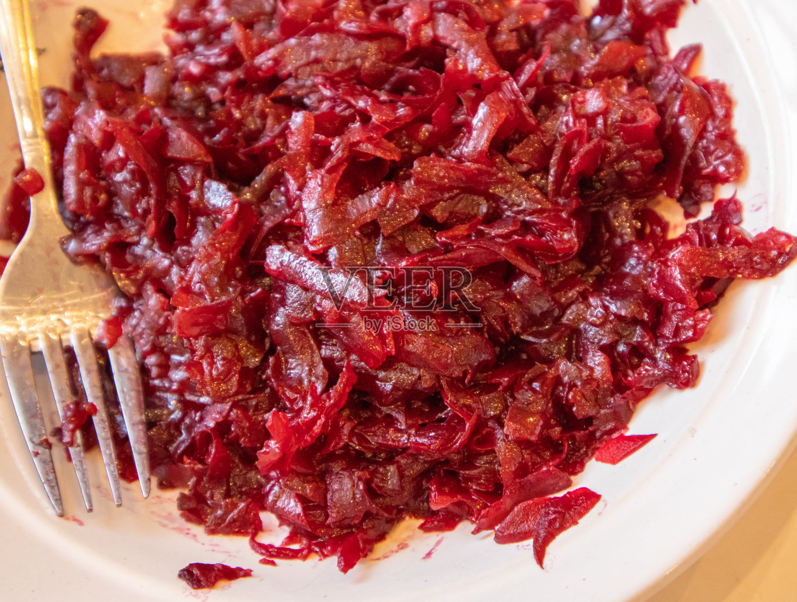 白盘上的煮碎甜菜根和叉子的特写，健康营养的概念，有机蔬菜照片摄影图片