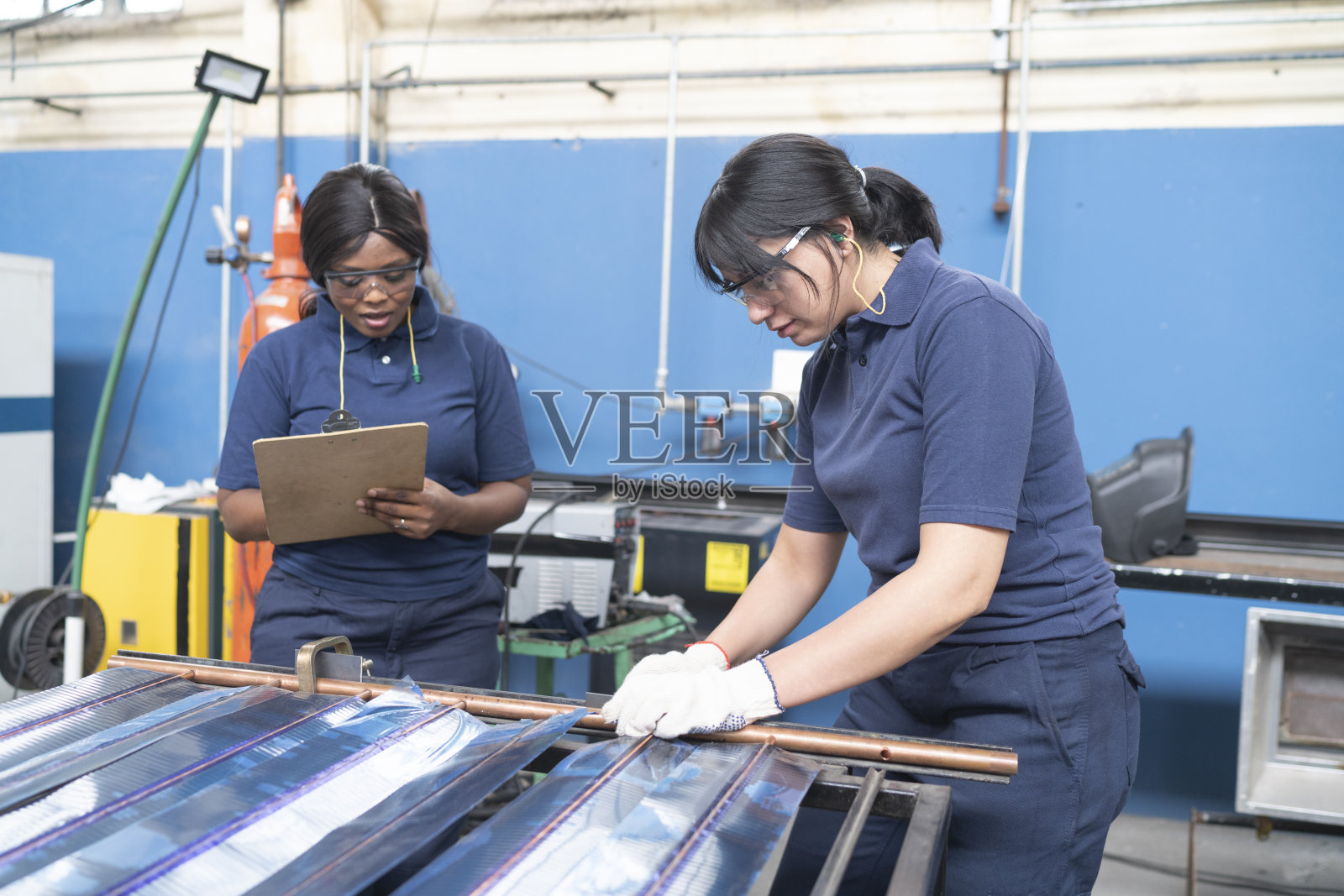 非裔美国女性主管，监督女性工人在太阳能电池板工厂制造电池板照片摄影图片