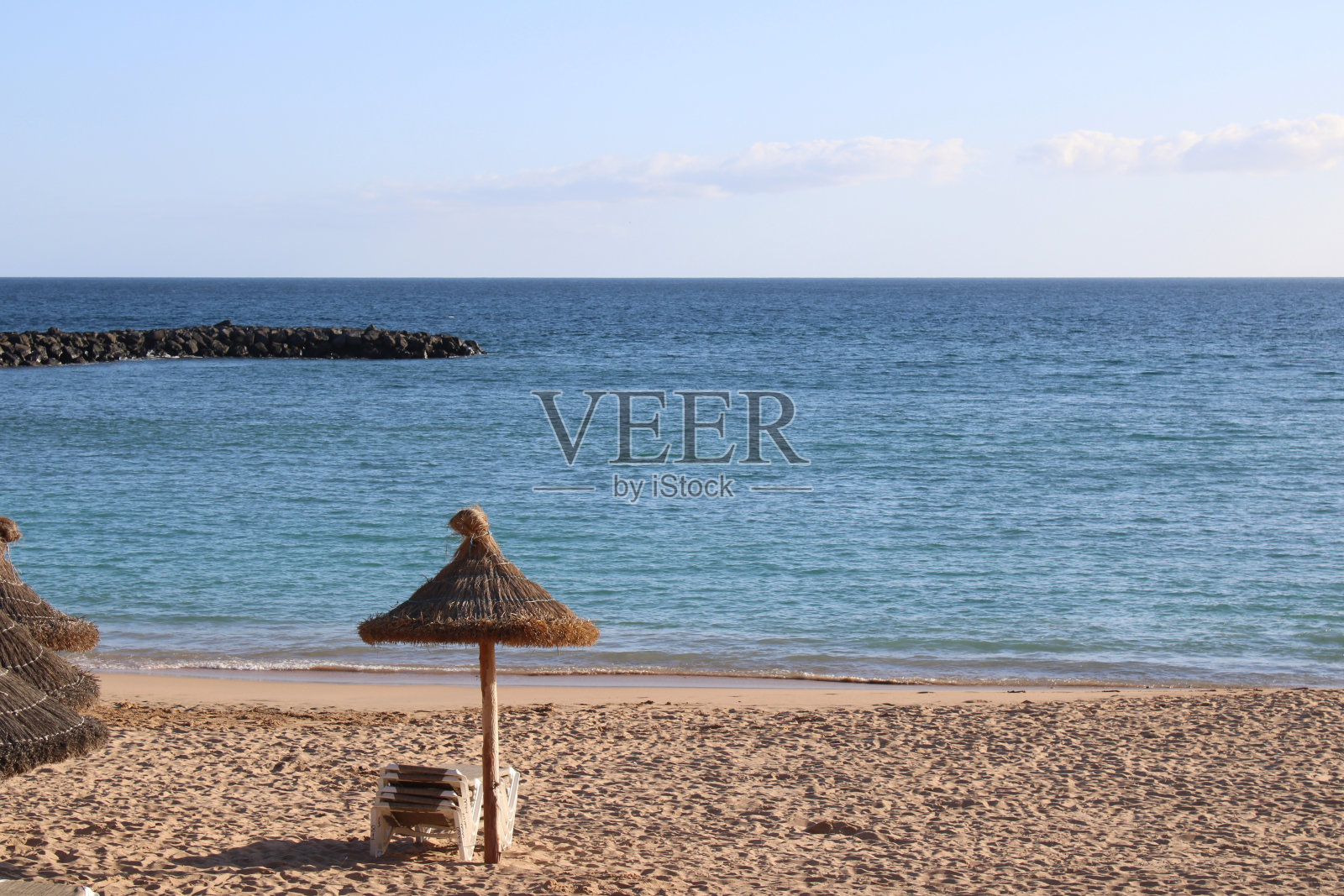 空旷的白色沙滩上孤零零的稻草天窗照片摄影图片