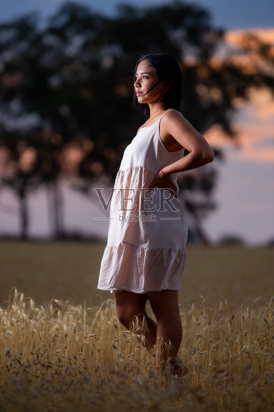 年轻女子在日落时享受大自然。照片摄影图片