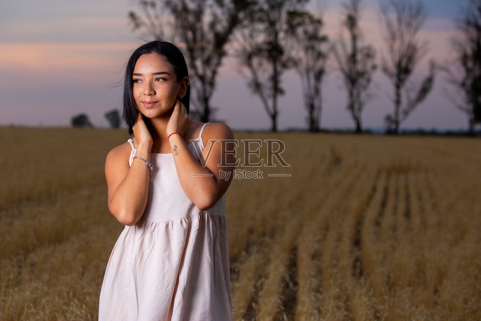 年轻女子在日落时享受大自然。照片摄影图片