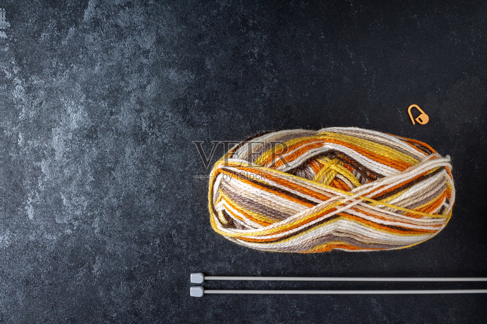 纱线和针织针绞在黑色背景上，复制空间照片摄影图片