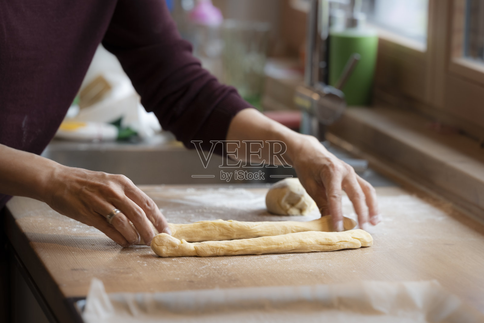女人们用手揉面团来制作复活节辫子照片摄影图片