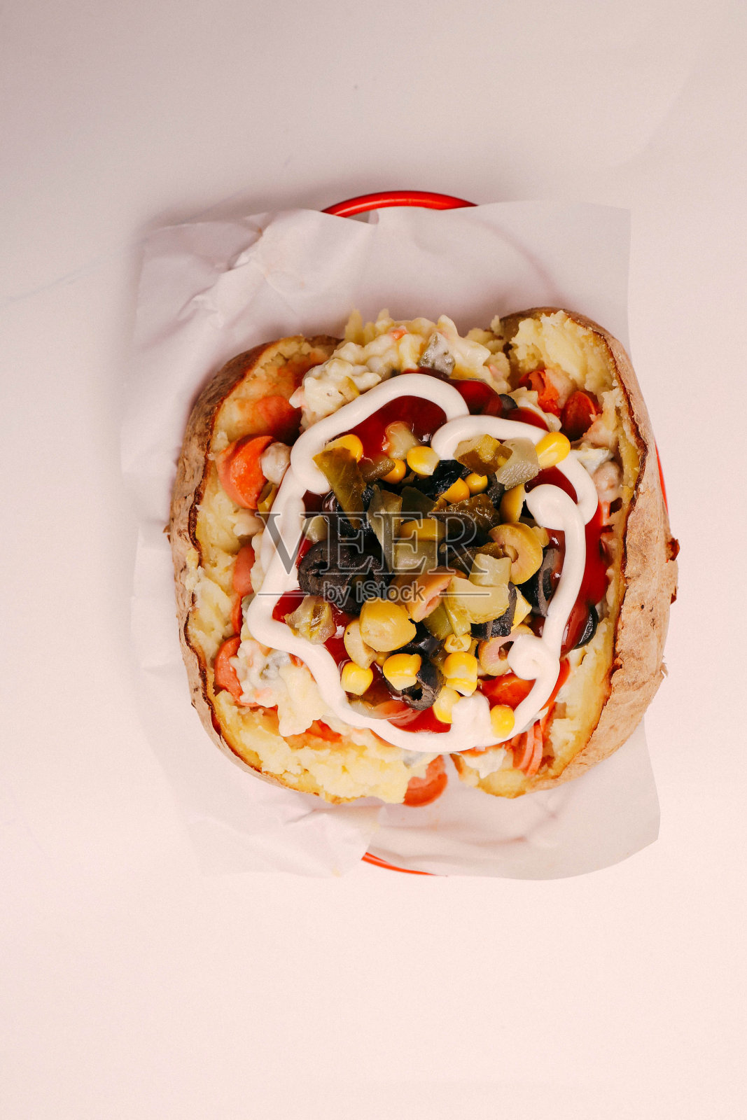 芝士，香肠，橄榄，辣椒和玉米馅的烤土豆照片摄影图片