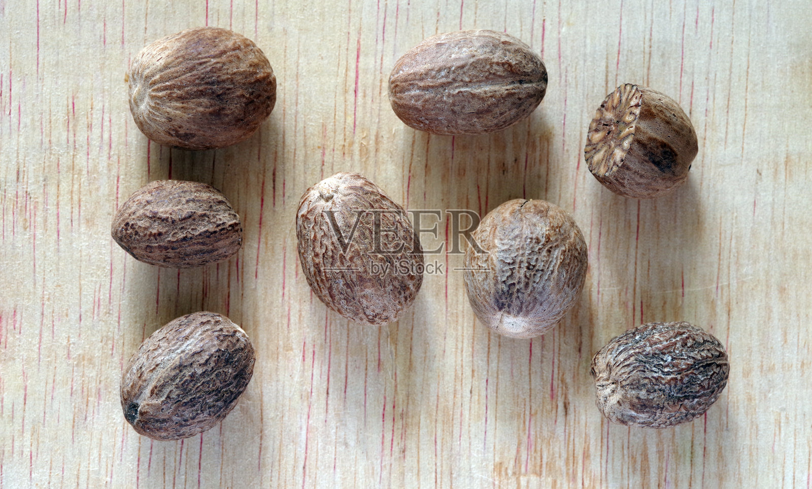 几个干肉豆蔻在木材纹理背景。照片摄影图片