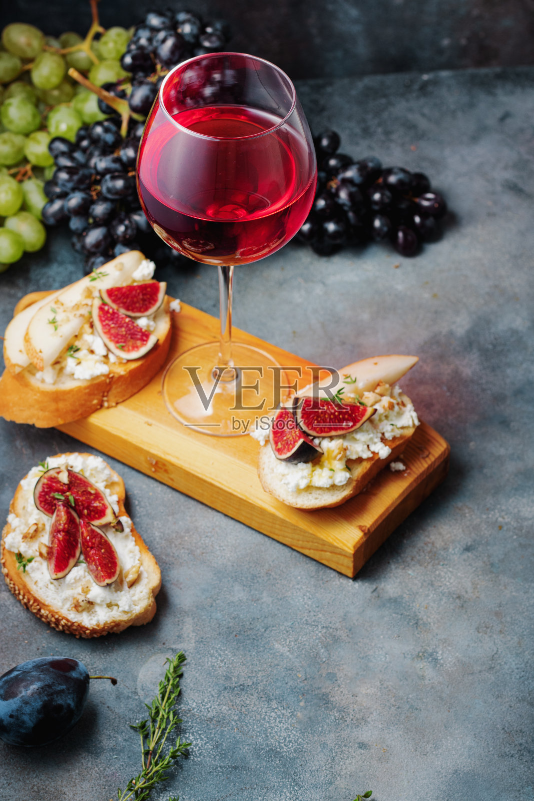 红酒配小吃烤面包配梨，白干酪，无花果，百里香，坚果和蜂蜜照片摄影图片