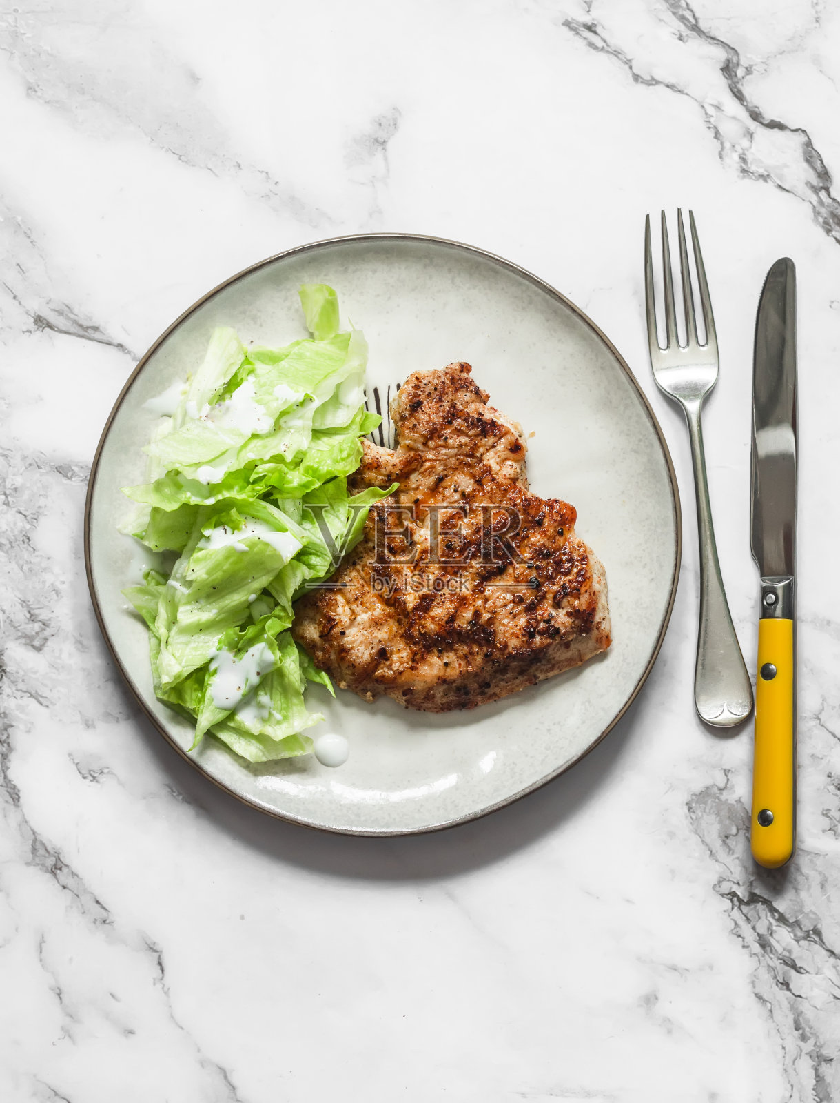 烤火鸡牛排和冰山希腊酸奶沙拉酱在一个轻背景，俯视图。美味健康的午餐照片摄影图片