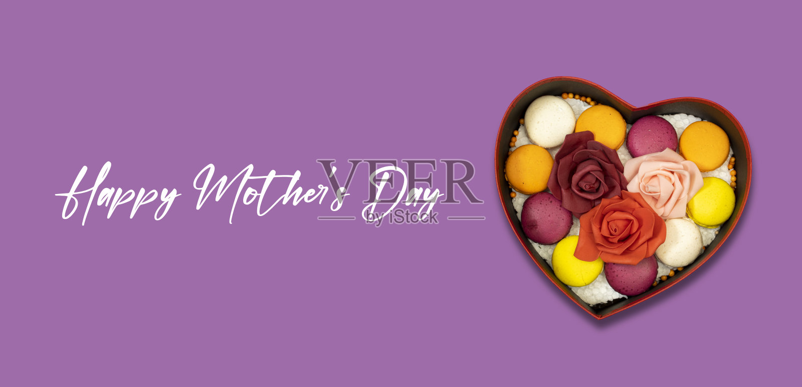 心形礼盒，法国彩色马卡龙饼干，红色和粉红色的玫瑰花，情人节或妇女或母亲节的节日照片摄影图片