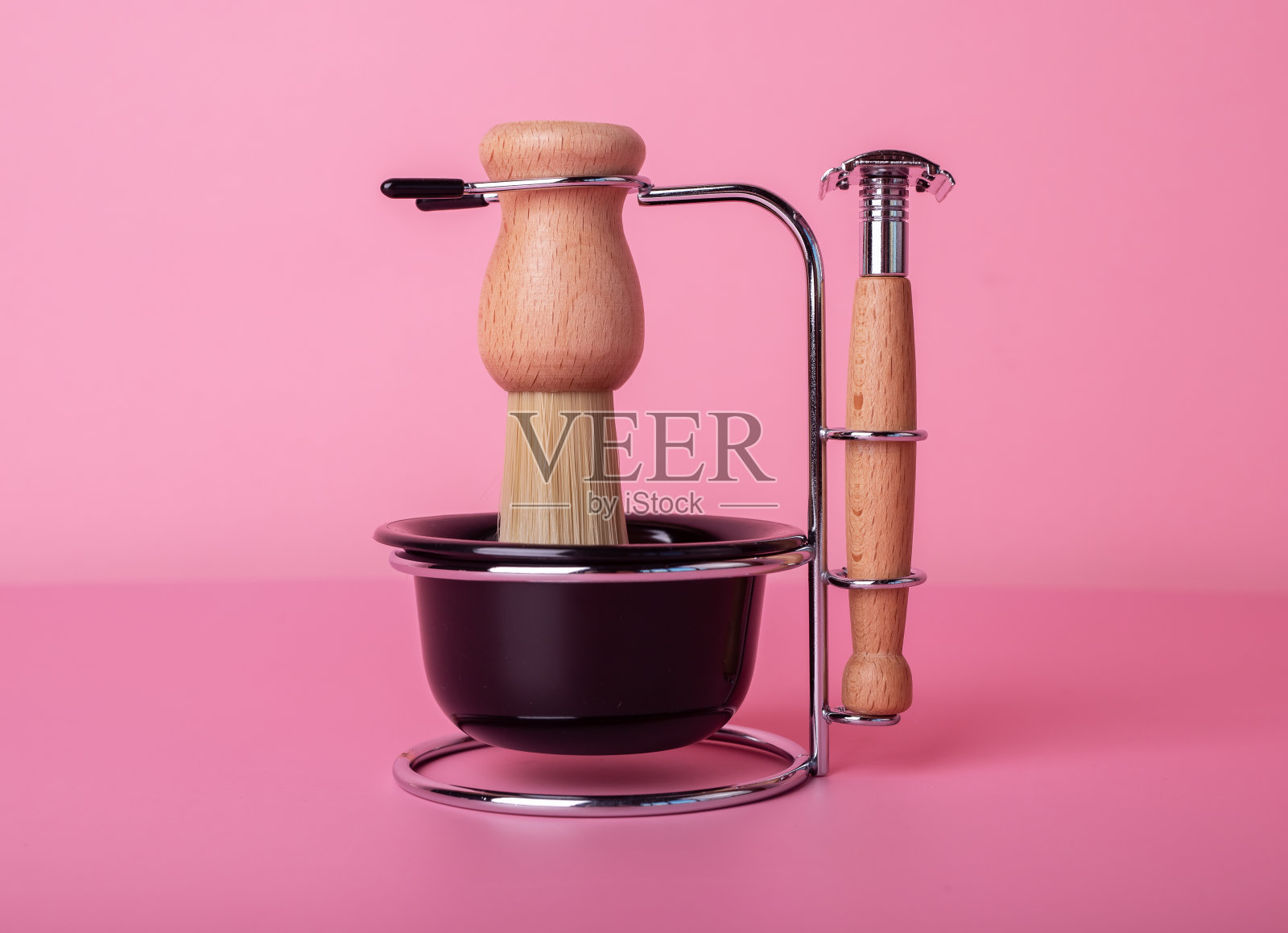 男士剃须工具，剃须刀，刷子，杯子泡沫在复古复古风格。修饰设置为粉色背景。卫生和面部护理理念照片摄影图片