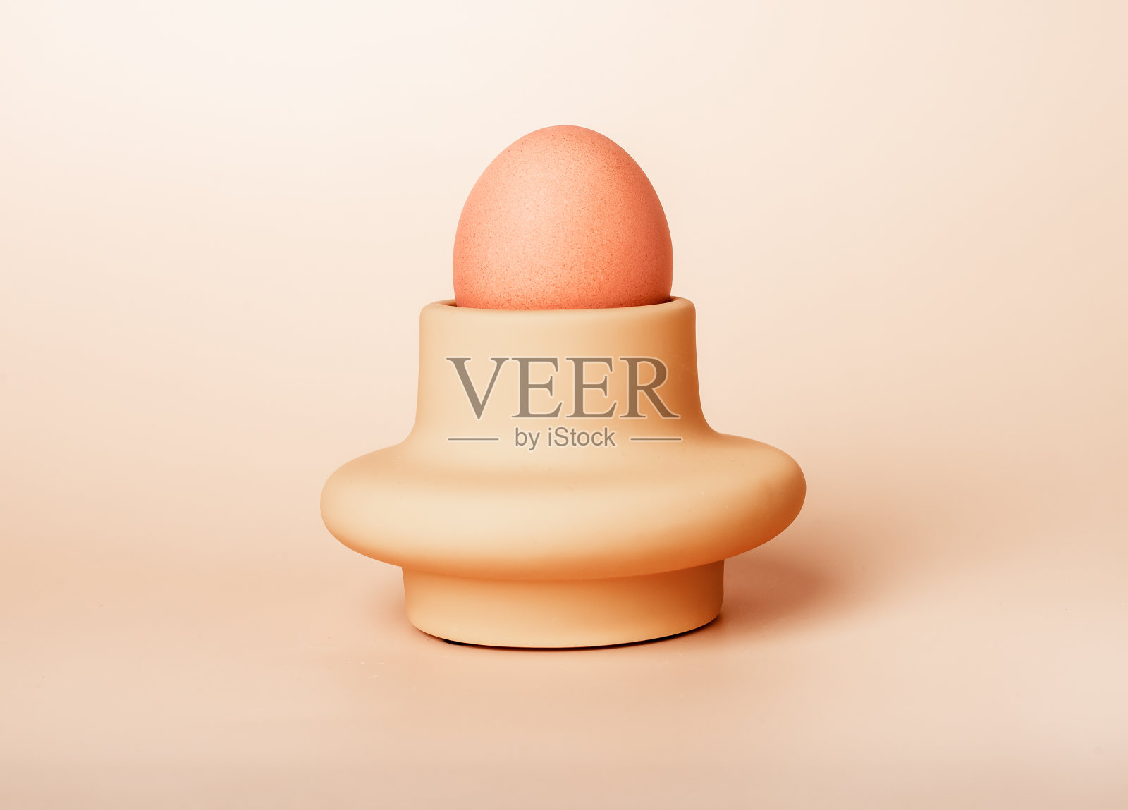 煮熟的鸡蛋放在米色背景的杯子，托盘或盘子里。复活节或营养农产品的概念。早餐食品照片摄影图片