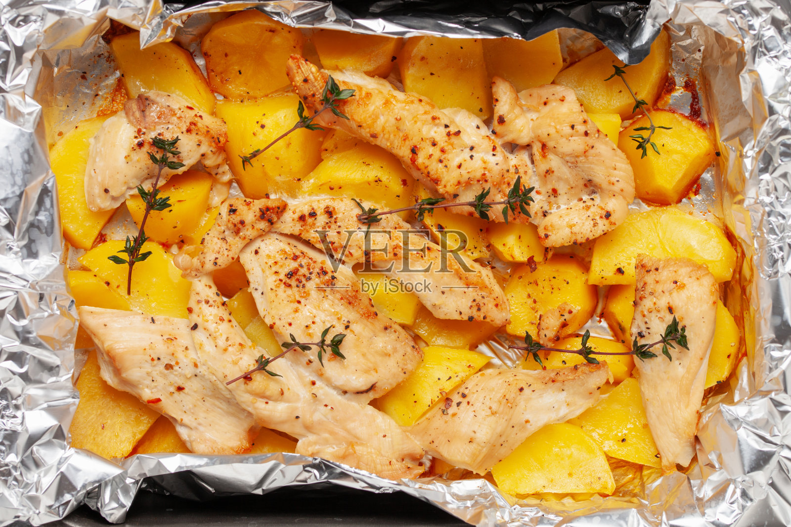 用锡箔烤的土豆和鸡排。简单的家庭食品。俯视图照片摄影图片