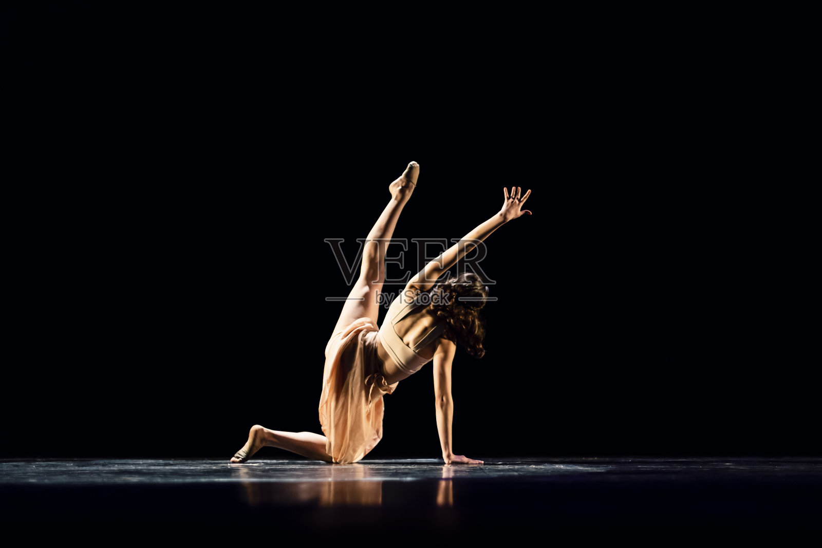 在黑暗的舞台上表演现代舞的少女照片摄影图片