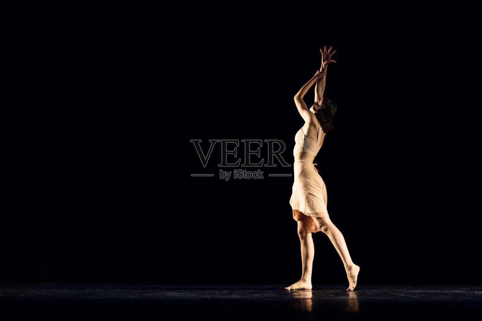 在黑暗的舞台上表演现代舞的少女照片摄影图片