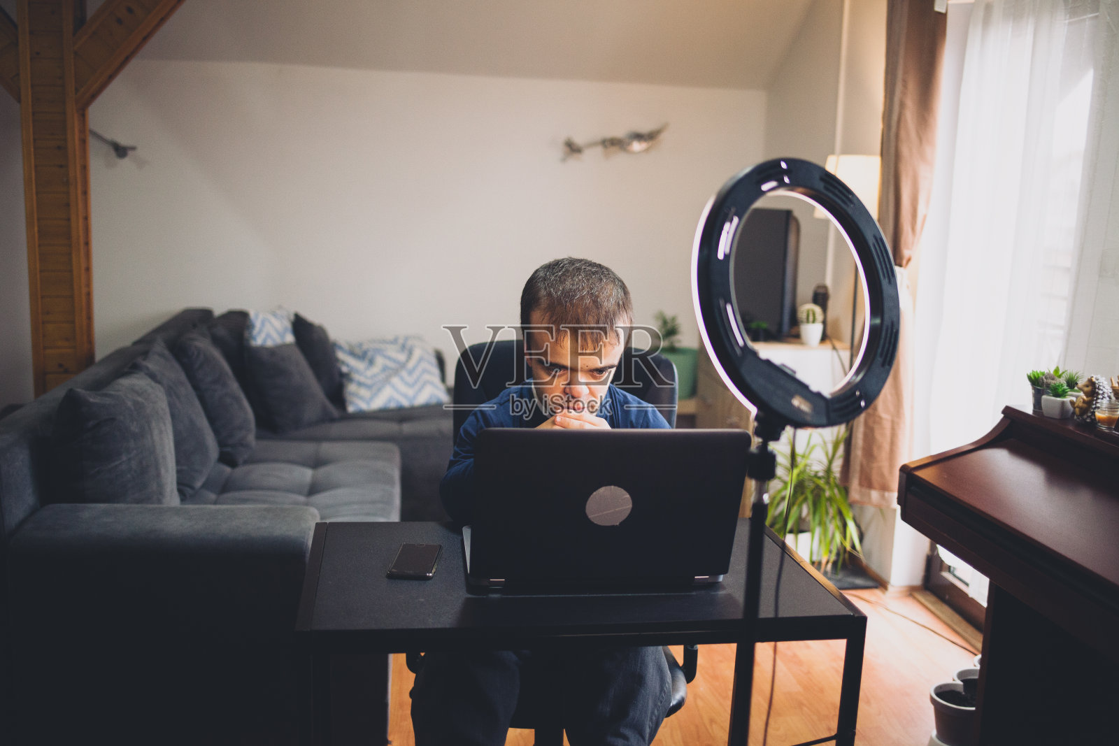 有侏儒症的年轻人在家在线工作，他很累照片摄影图片