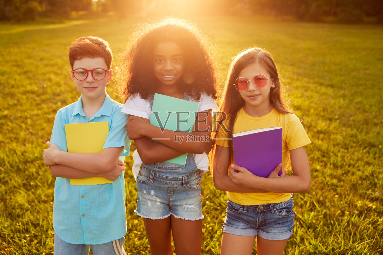 公园里各种各样的孩子拿着课本照片摄影图片