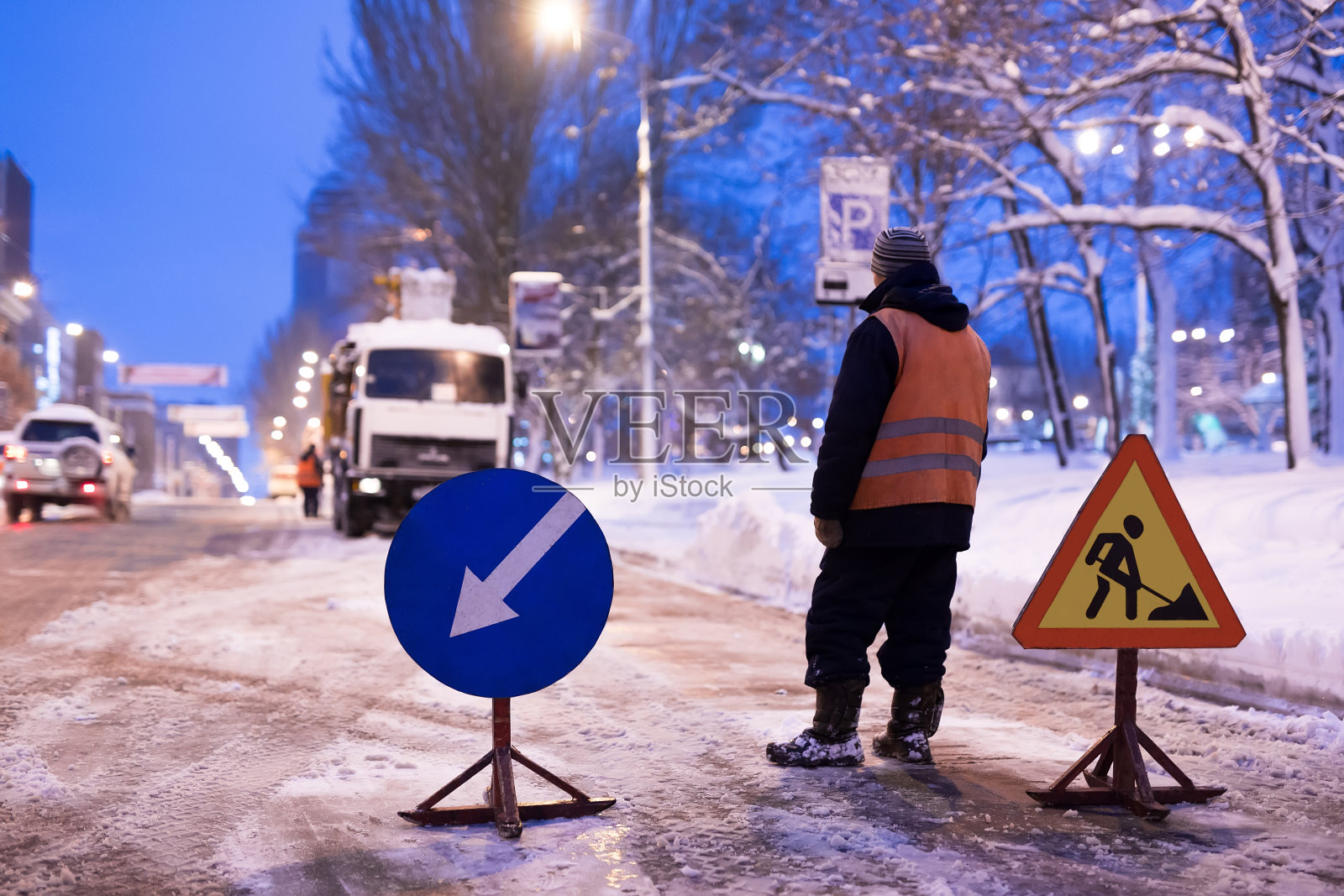 扫雪机清除城市街道上的积雪。警告路标照片摄影图片