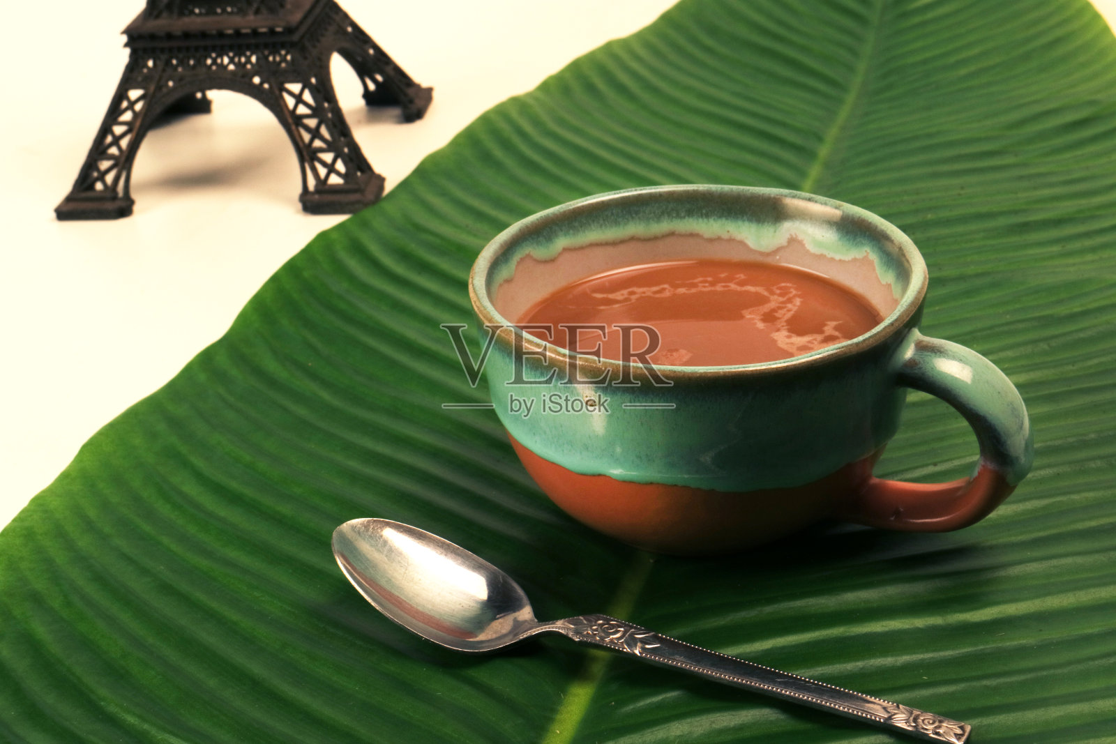咖啡拿铁卡布奇诺在一杯香蕉叶与埃菲尔铁塔微型法国背景照片摄影图片