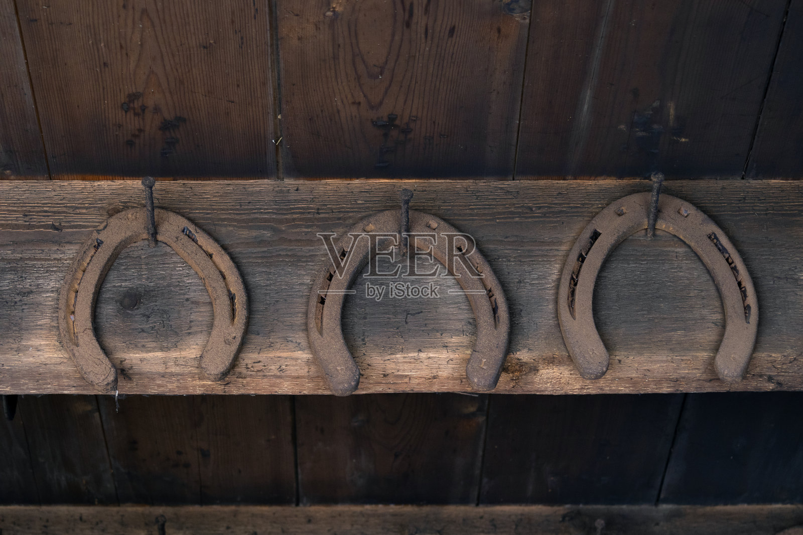 谷仓的墙上挂着生锈的老式马蹄铁照片摄影图片