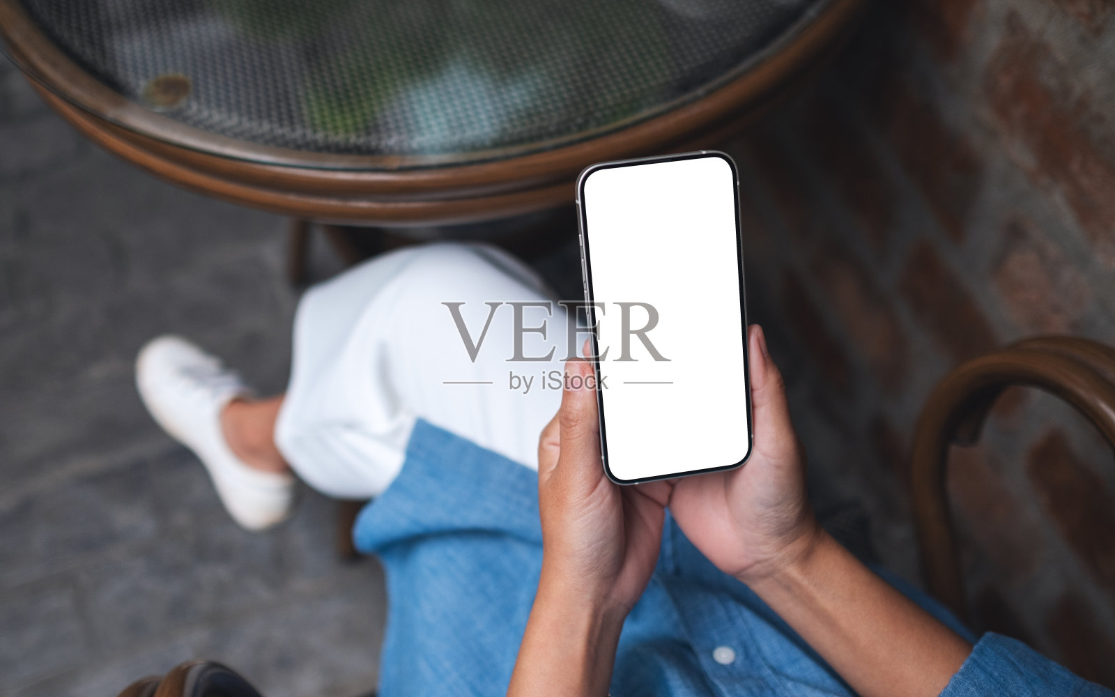 俯视图模型的一个女人拿着手机在户外的空白屏幕的形象照片摄影图片