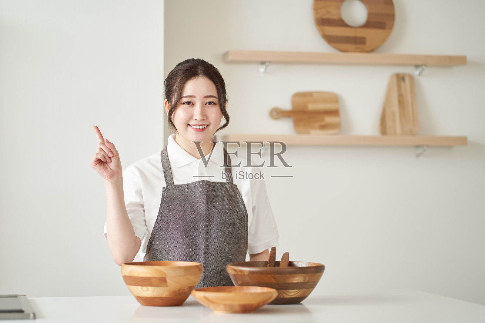 一个亚洲女人在厨房里指指点点照片摄影图片