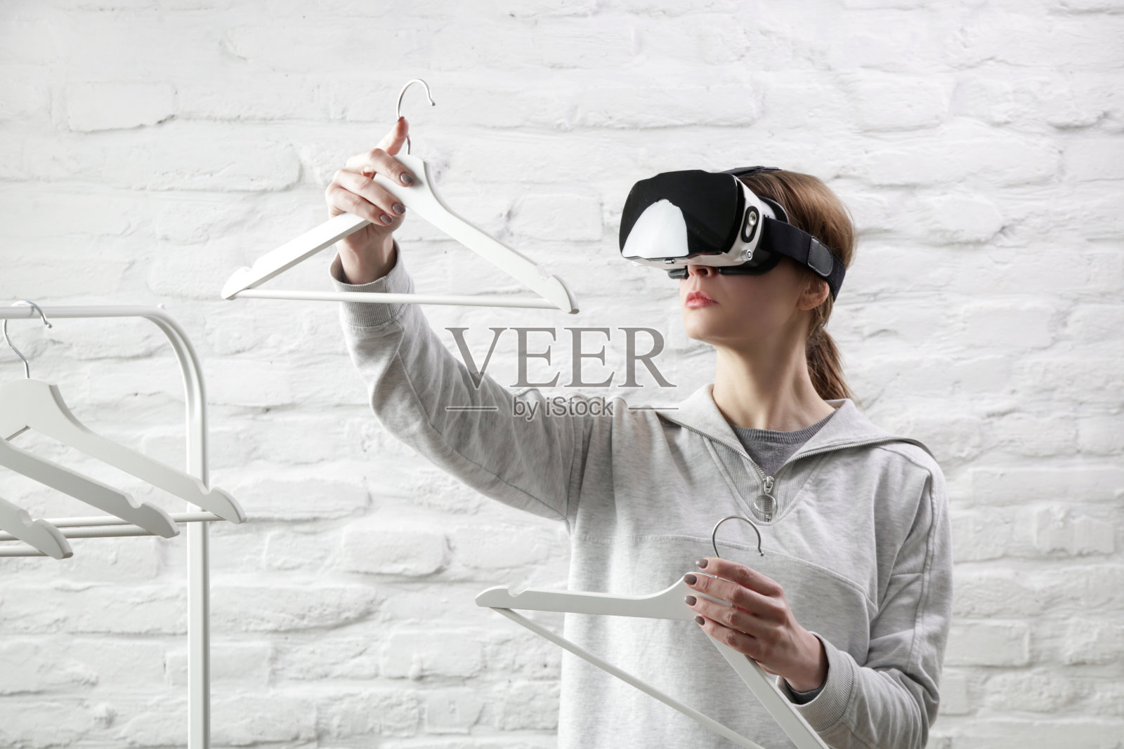 女性肖像与VR眼镜选择服装从衣架。虚拟现实体验与未来技术概念。照片摄影图片