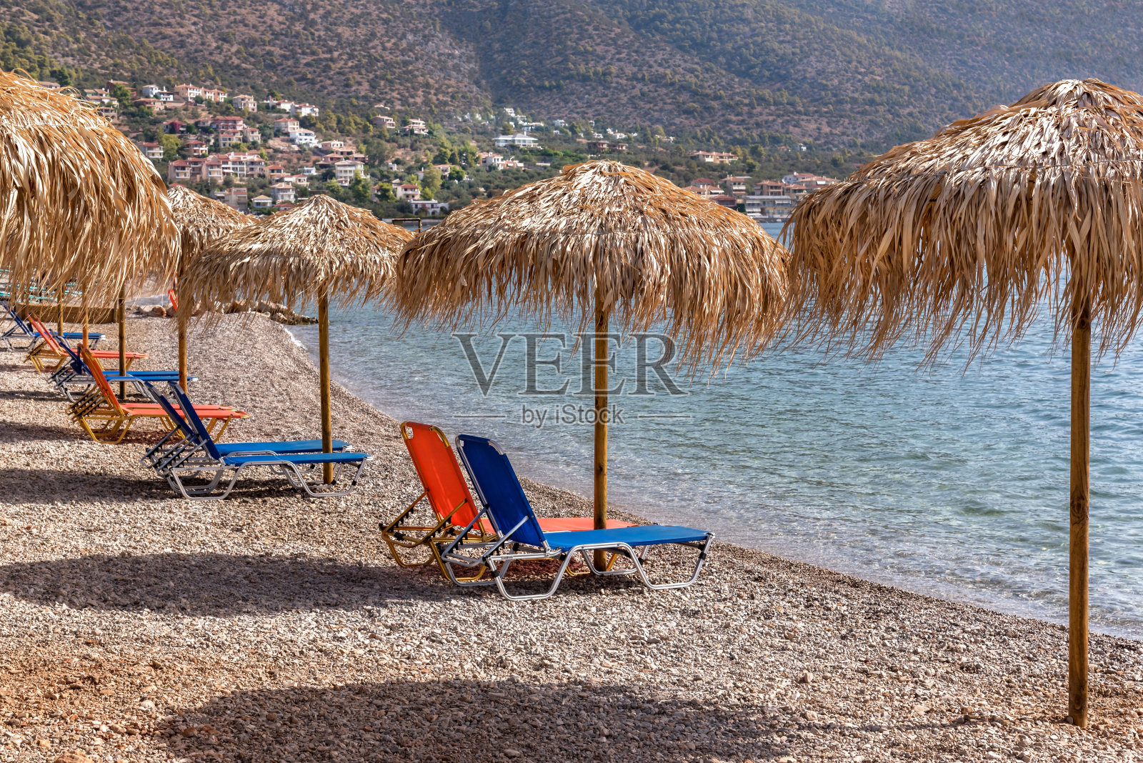 沙滩上的竹伞和躺椅。照片摄影图片