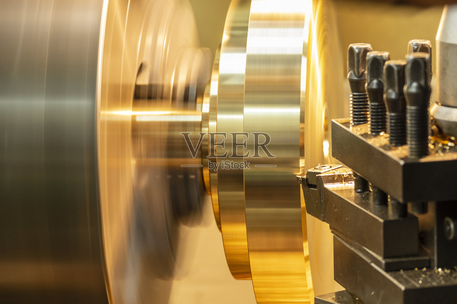 近景车床用车床工具完成对黄铜盘零件的切割。照片摄影图片