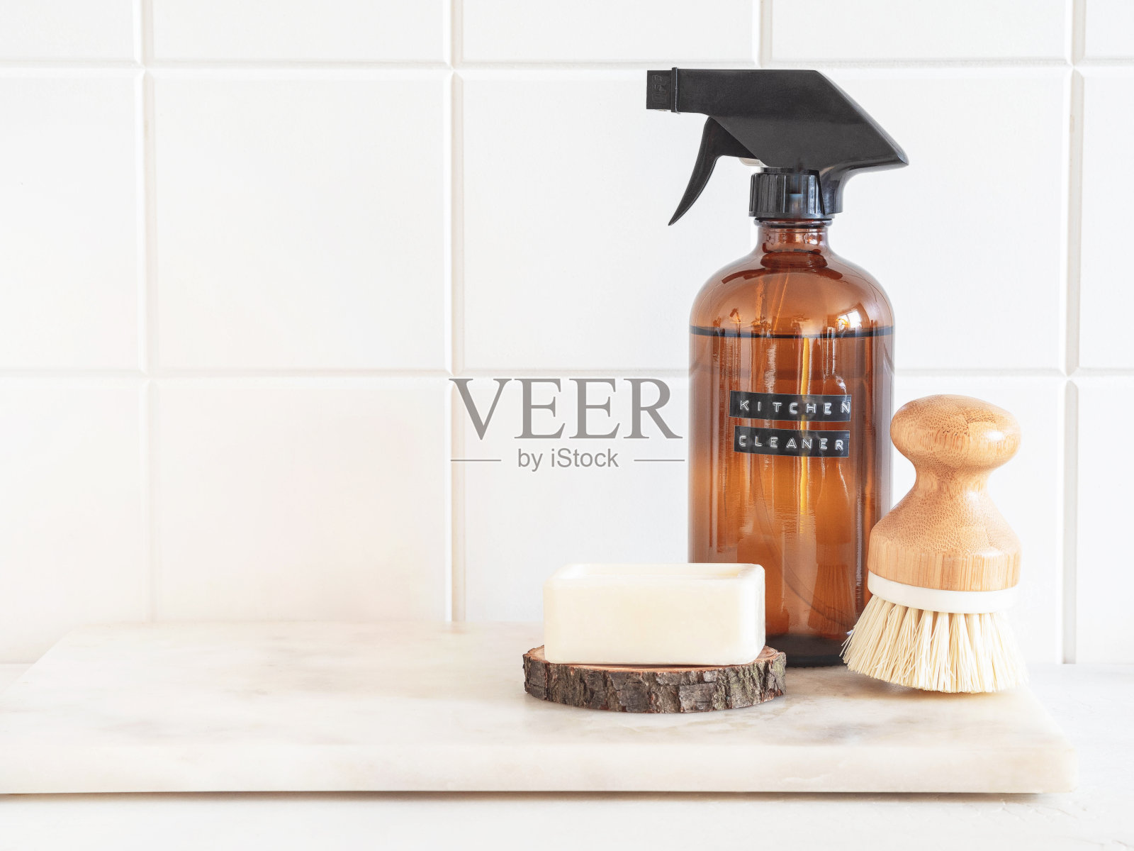 大理石架子上放着一个琥珀色的瓶子，里面有洗涤液、刷子和肥皂。照片摄影图片