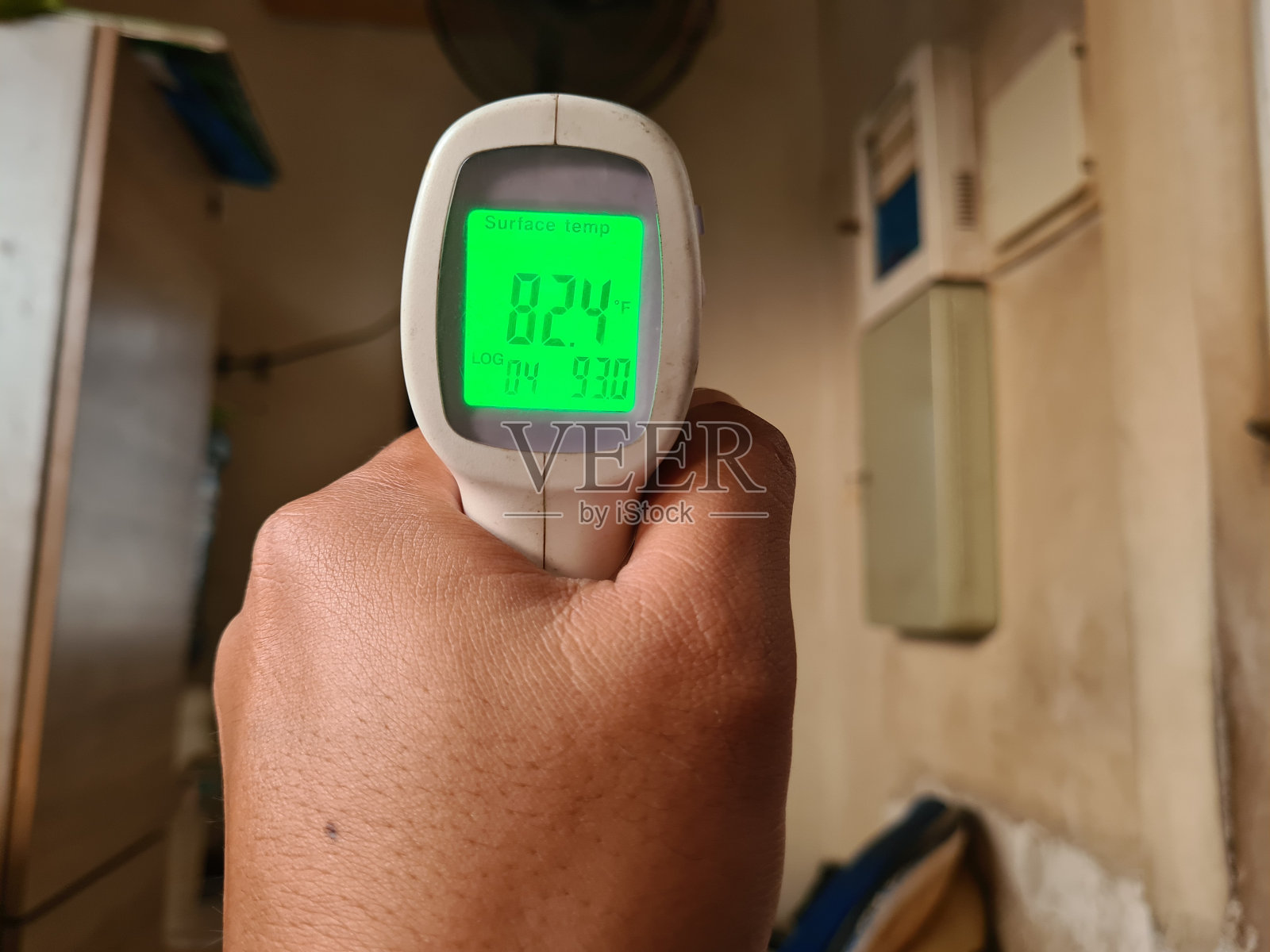 走近成年人的手拿着温度计枪检查房间的温度照片摄影图片