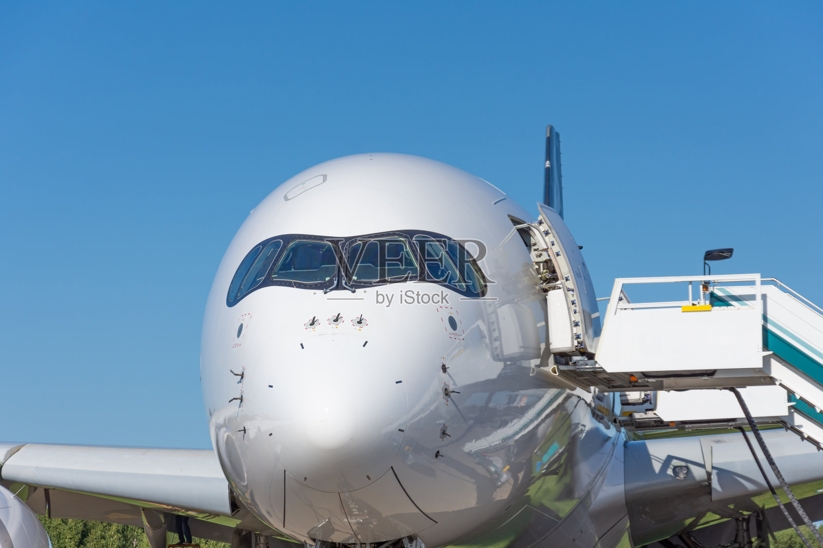 宽体客机。飞机座舱挡风玻璃和机头，带梯子。照片摄影图片