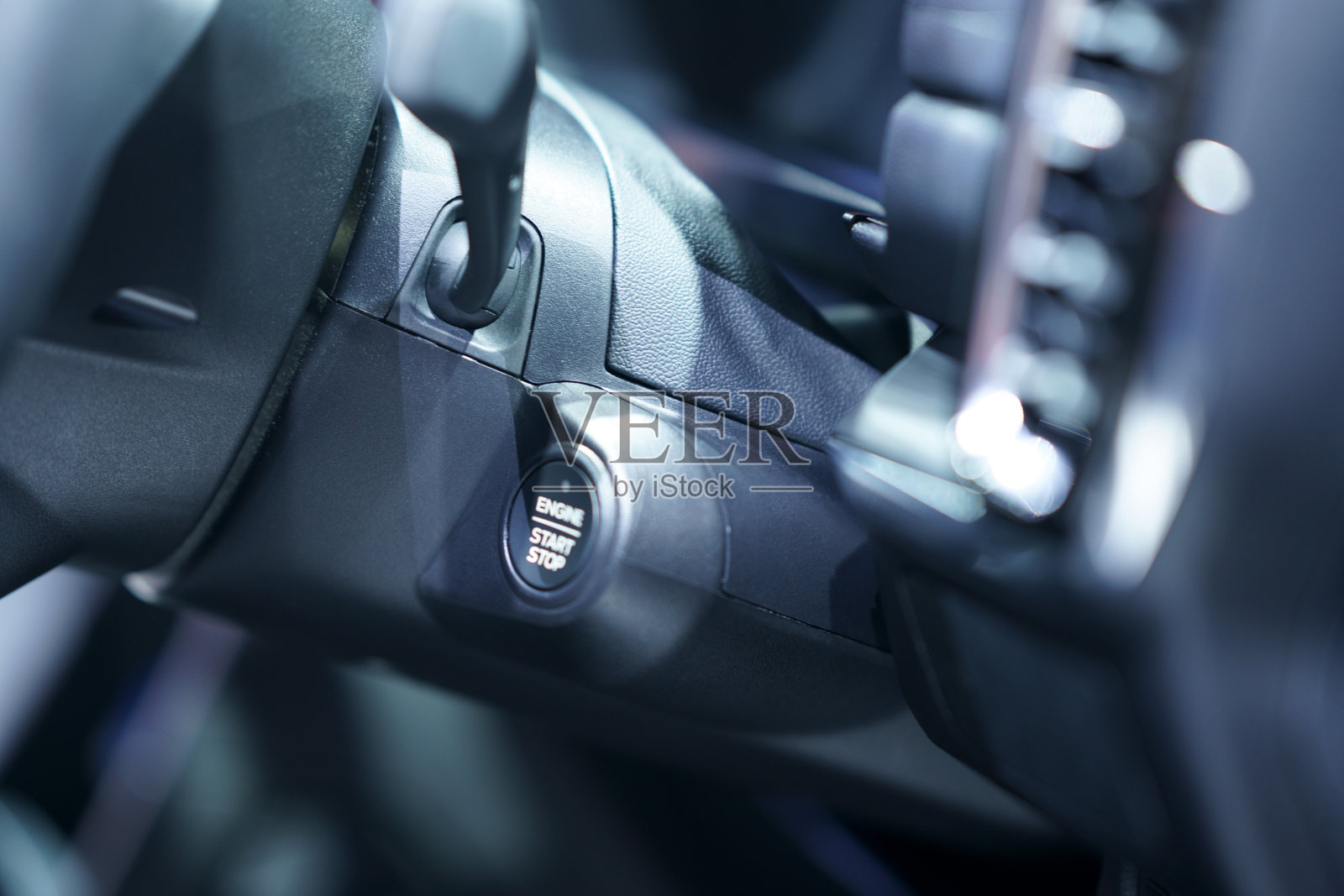 仪表盘上的汽车启动按钮。引擎启动写在按钮上。近距离的焦点。照片摄影图片