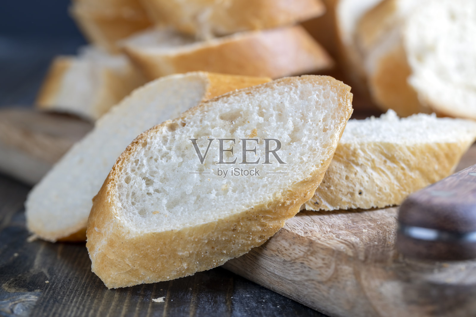 在砧板上切成片的小麦法棍照片摄影图片