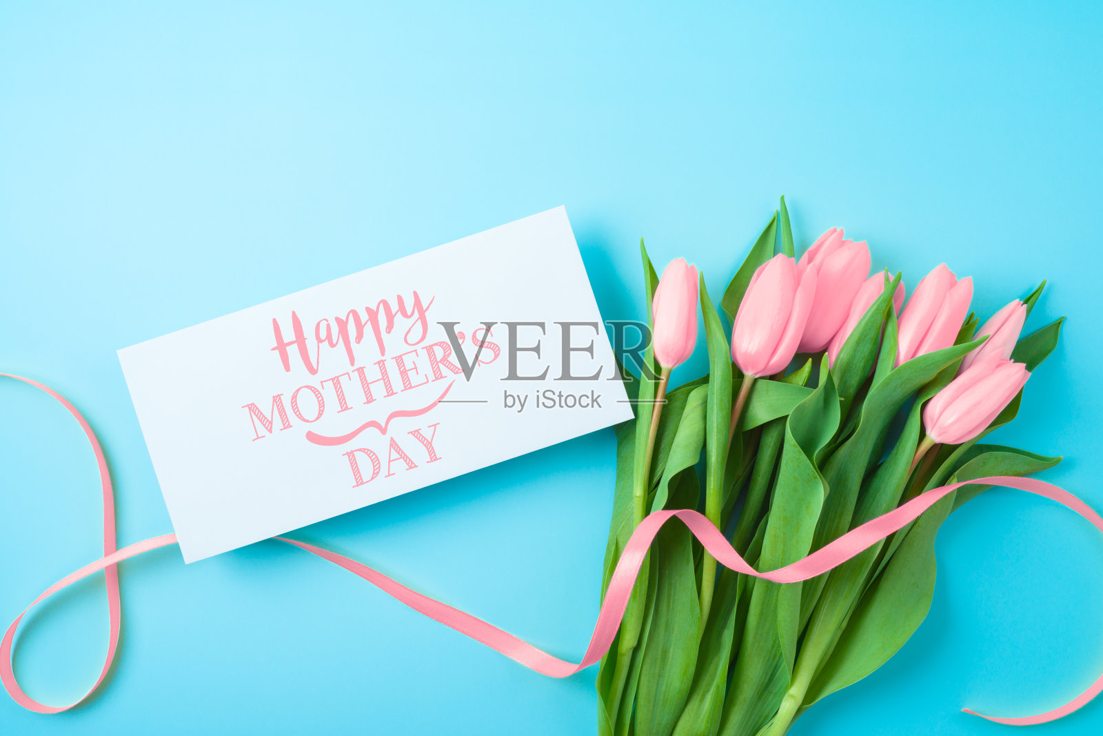 快乐的母亲节概念贺卡和美丽的郁金香花在蓝色的背景。平铺，俯视图照片摄影图片