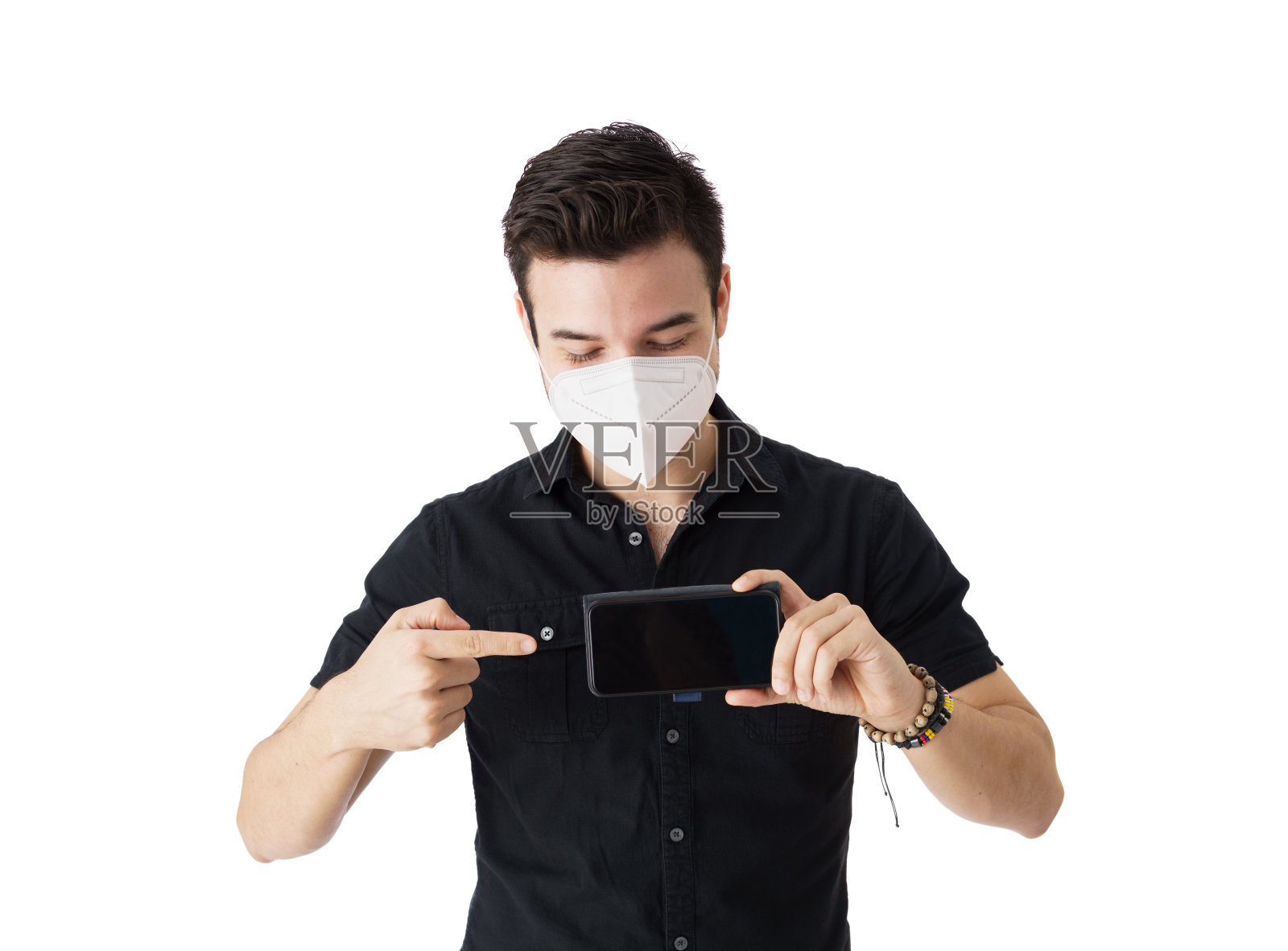 戴口罩的男子指着智能手机屏幕照片摄影图片