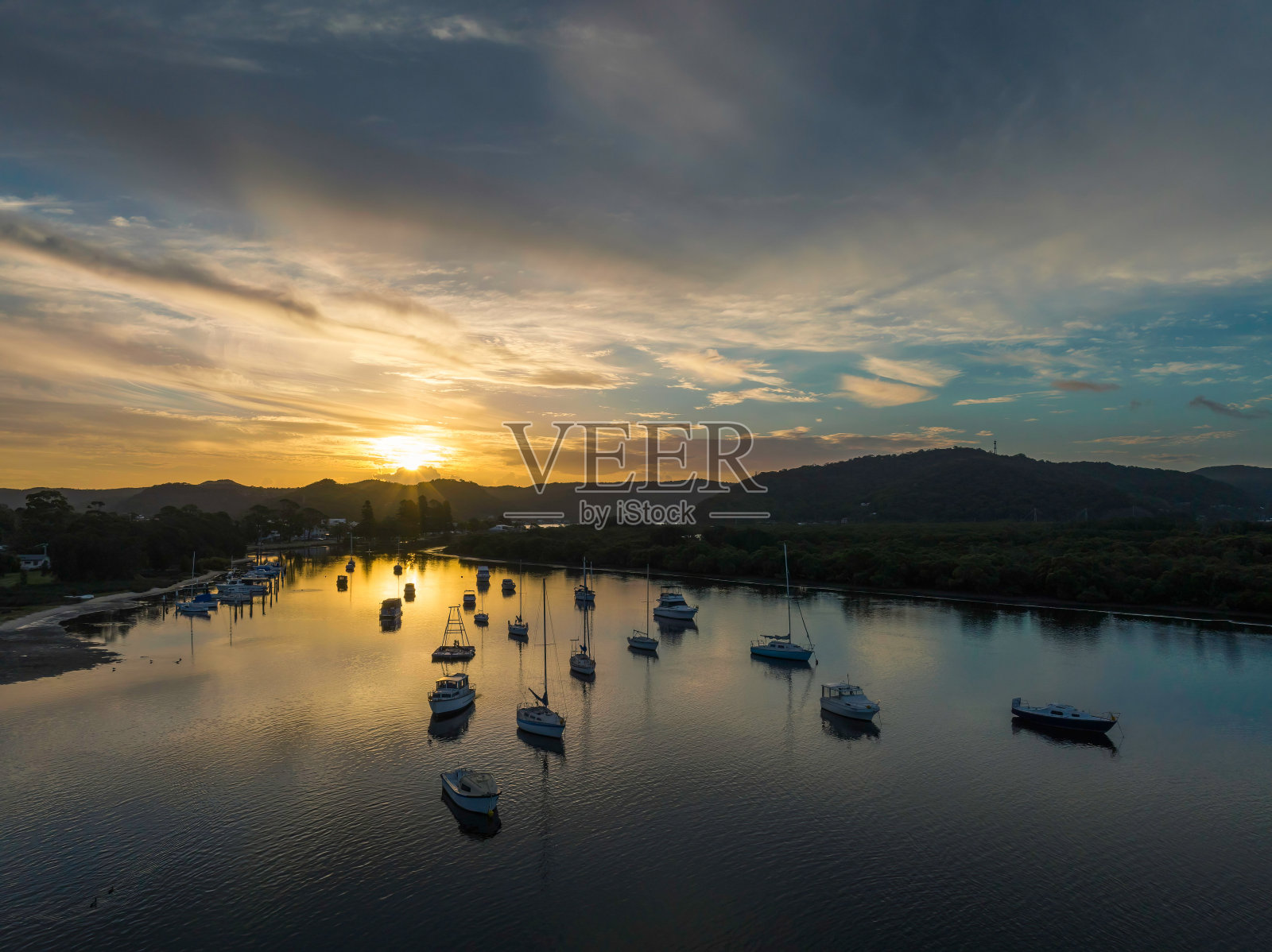 当太阳在海湾的阳光下落下照片摄影图片