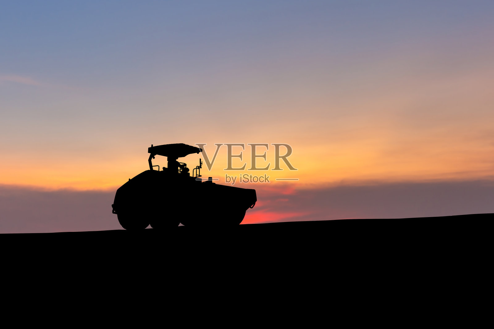 道路施工工地的压实机、振动压路机、沥青摊铺机、道路施工重型设备的剪影照片摄影图片