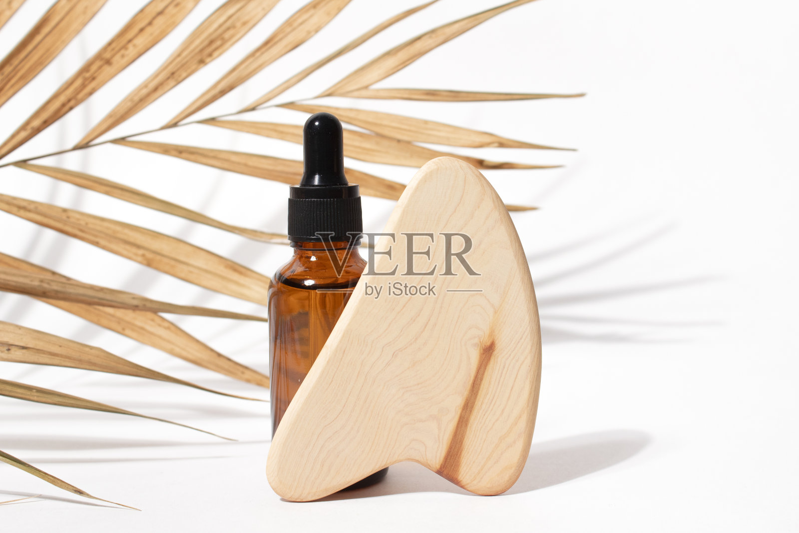 滴管化妆油瓶和木制挂沙按摩工具用干棕榈叶。天然有机化妆品、生态乳液、精华液、血清。芳香疗法照片摄影图片