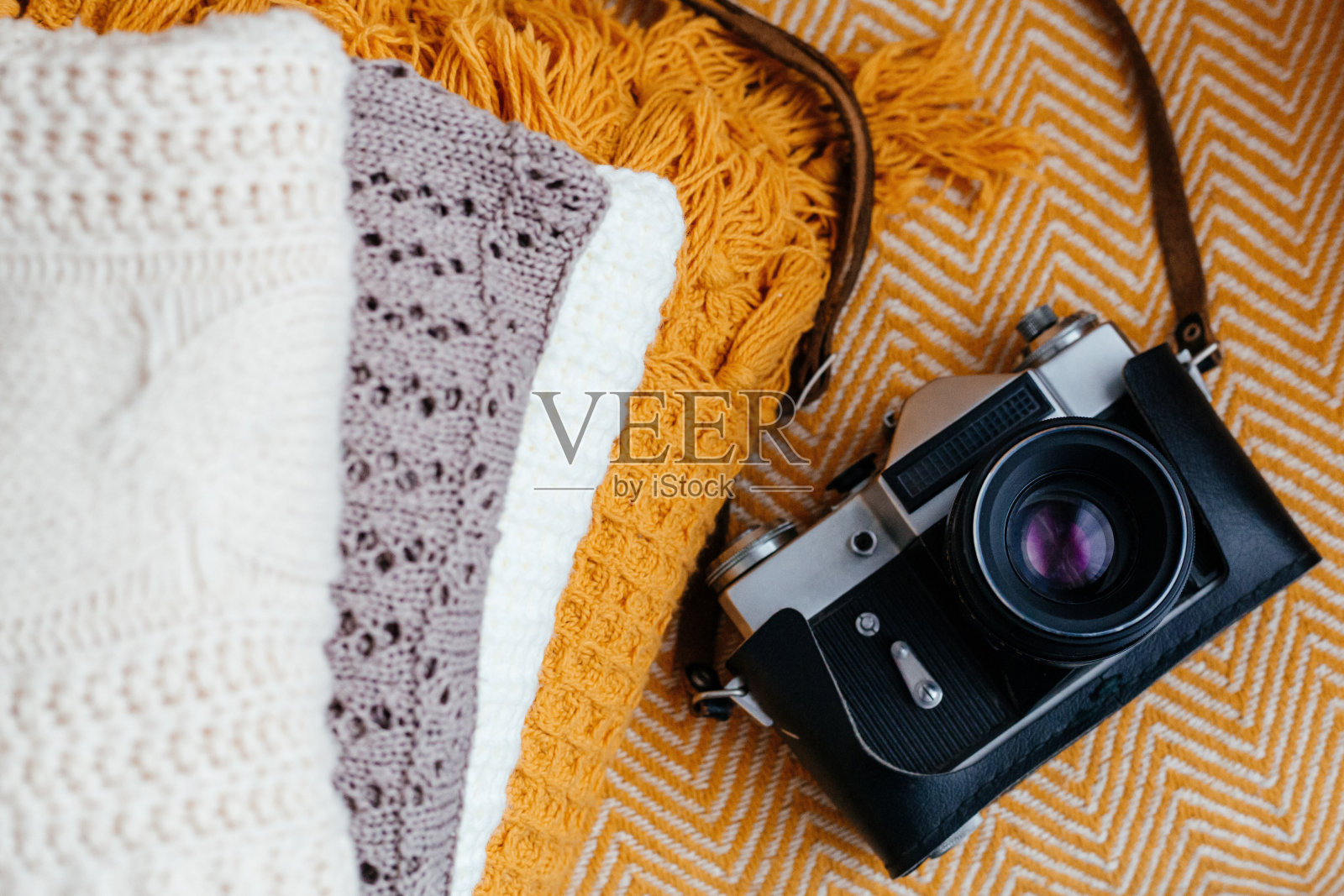 堆叠柔软温暖的格子和复古相机，俯视图。照片摄影图片