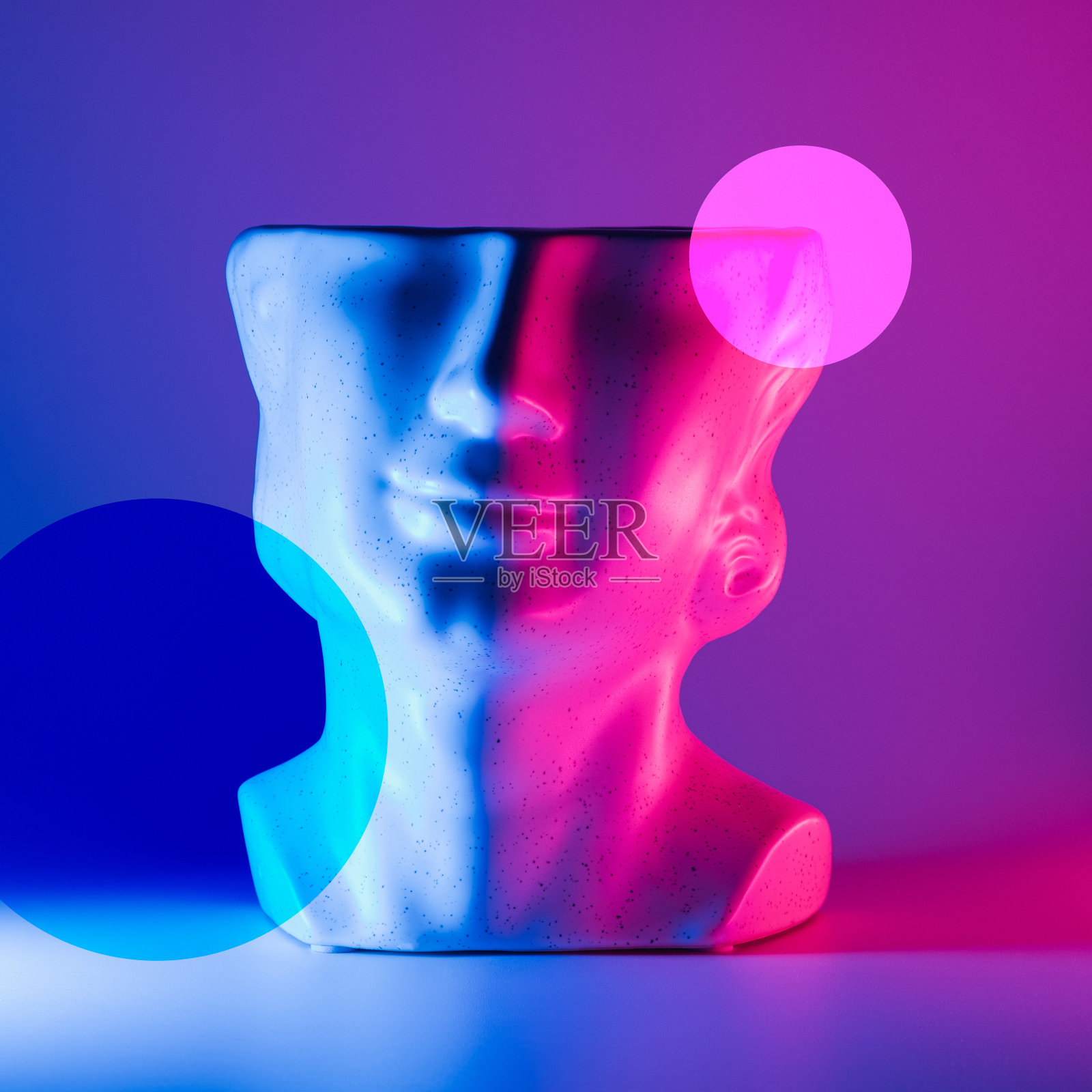 在霓虹灯照明的背景上切割石头头。和插图。照片摄影图片