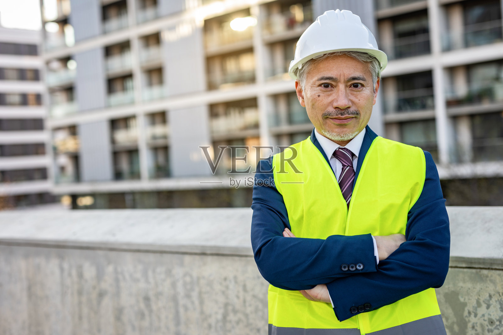 一位土木工程师的肖像，他身后是建筑物照片摄影图片