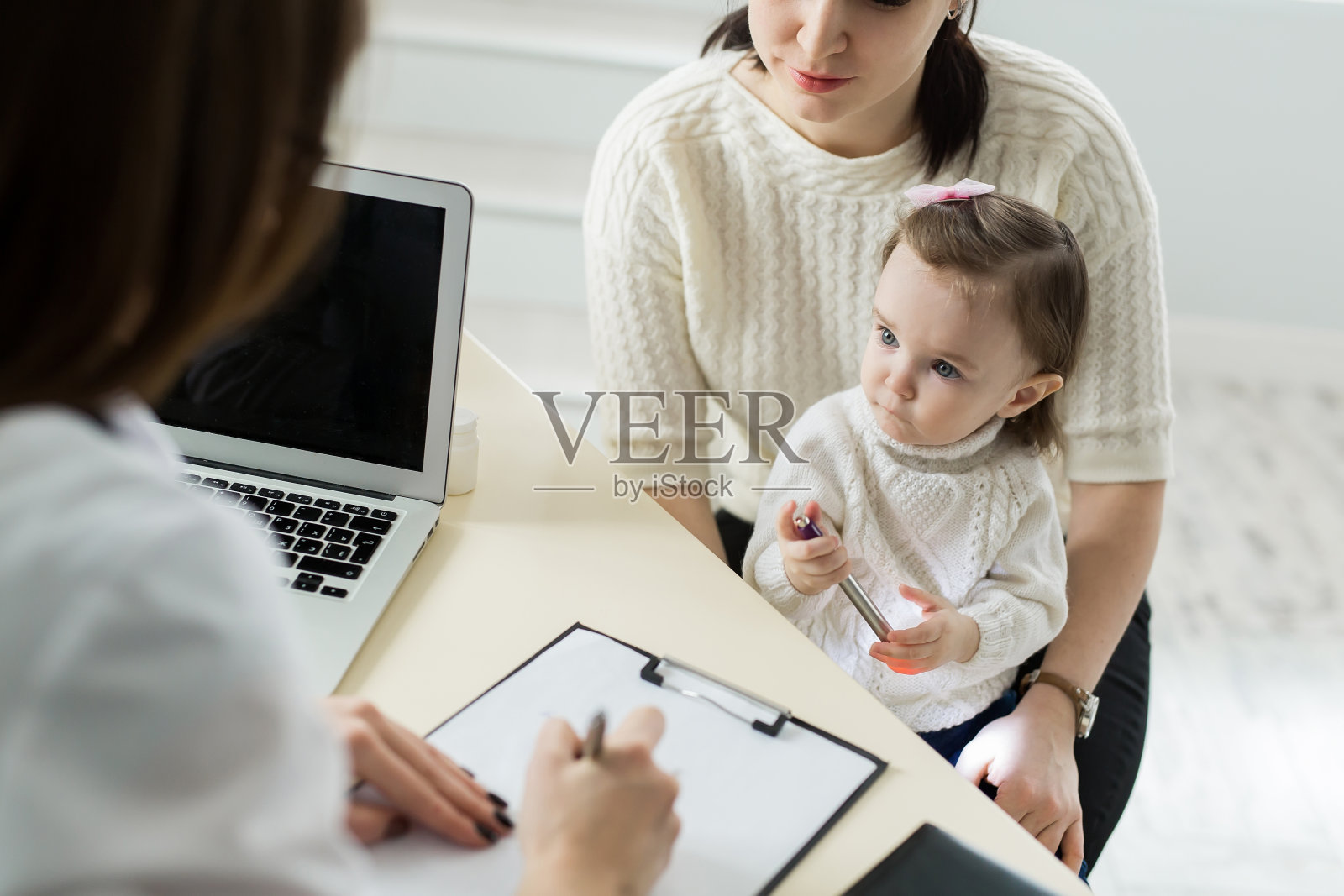 儿科医生在医院与母亲和儿童会面。照片摄影图片