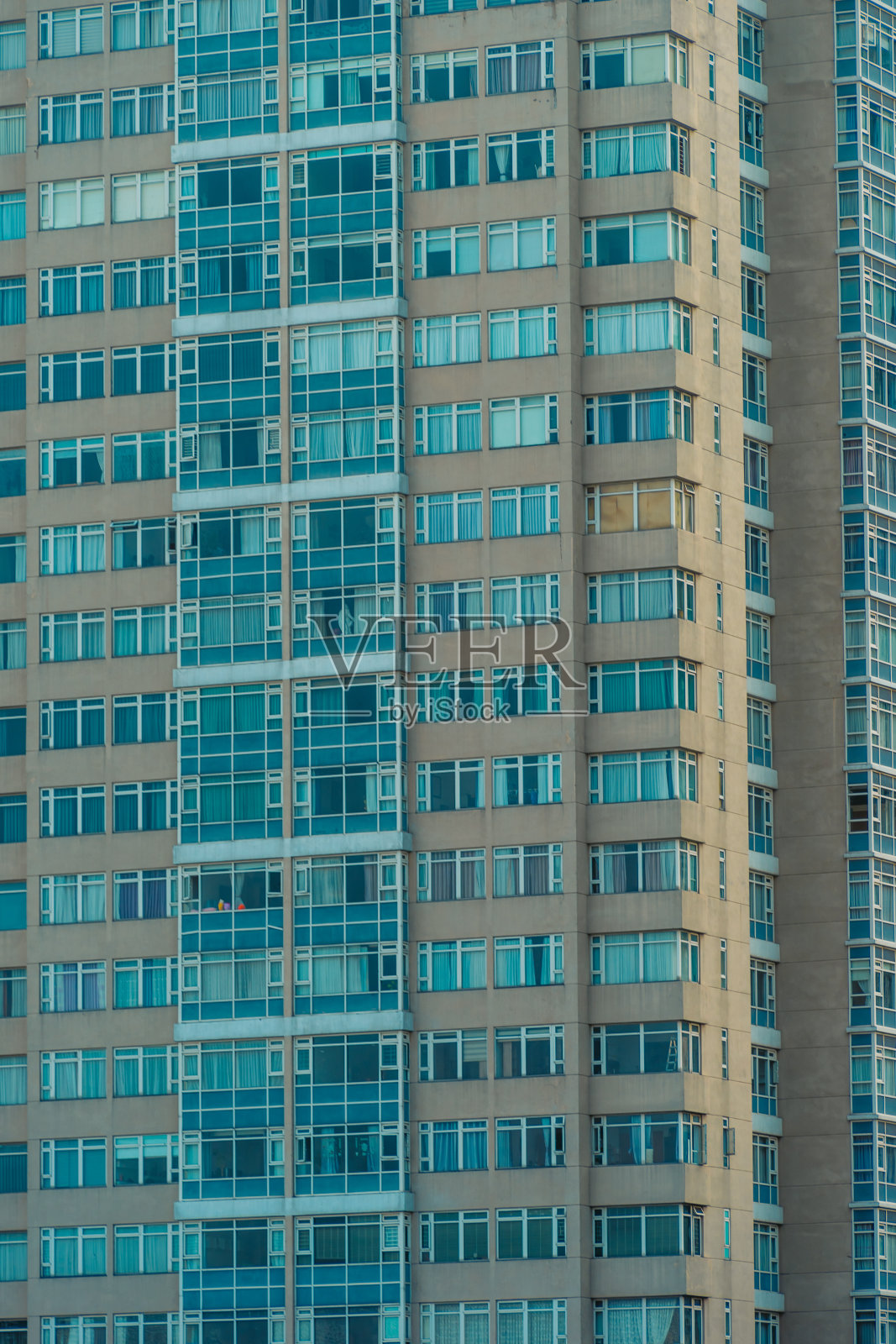 现代城市高层建筑的玻璃幕墙，展示了白天人类活动使用的照明，能源的使用。白天摩天大楼的窗户闪闪发光。照片摄影图片