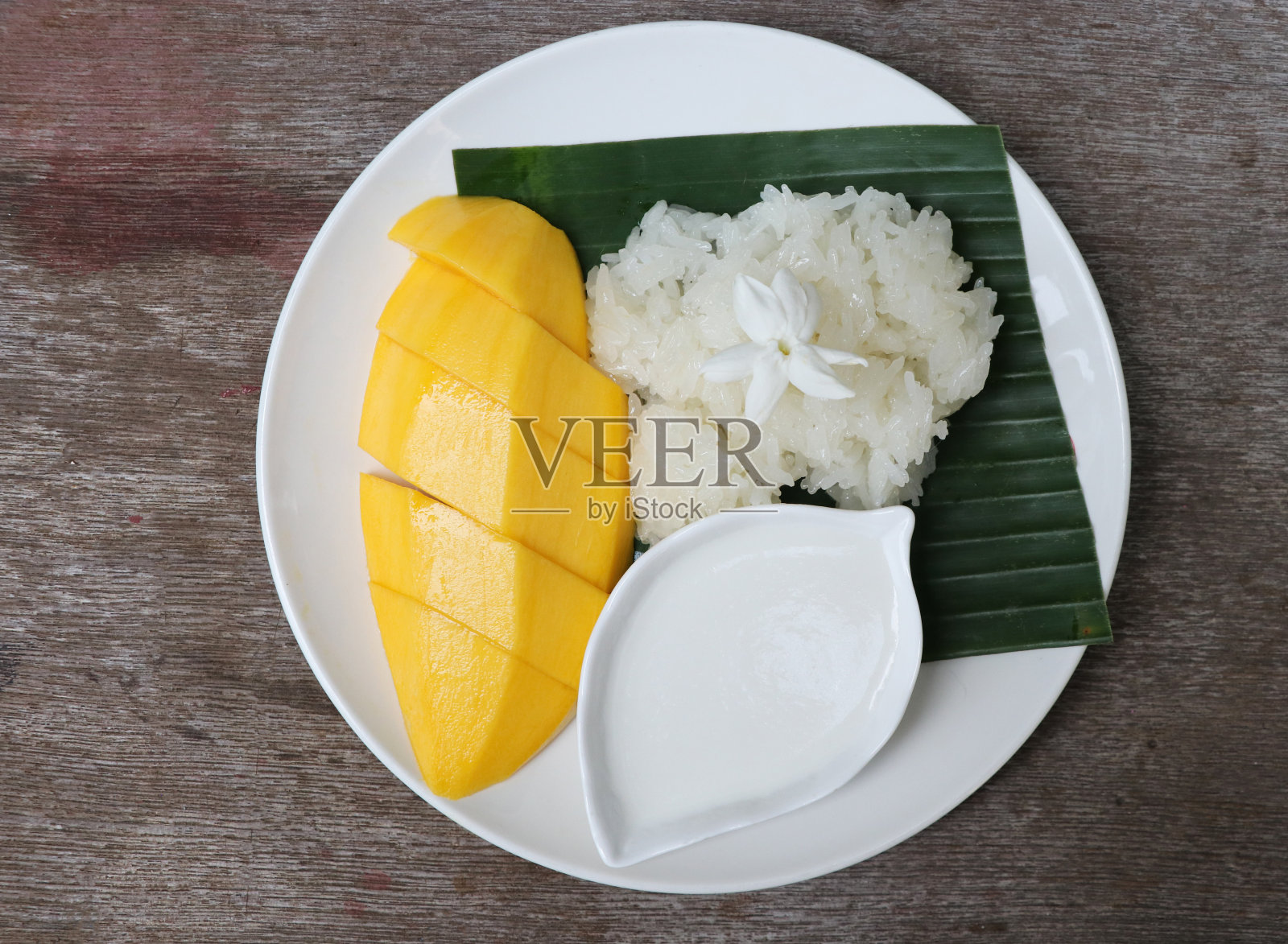 香甜的芒果配上糯米，在白色的盘子里浇上茉莉花，这是亚洲的夏季美食照片摄影图片