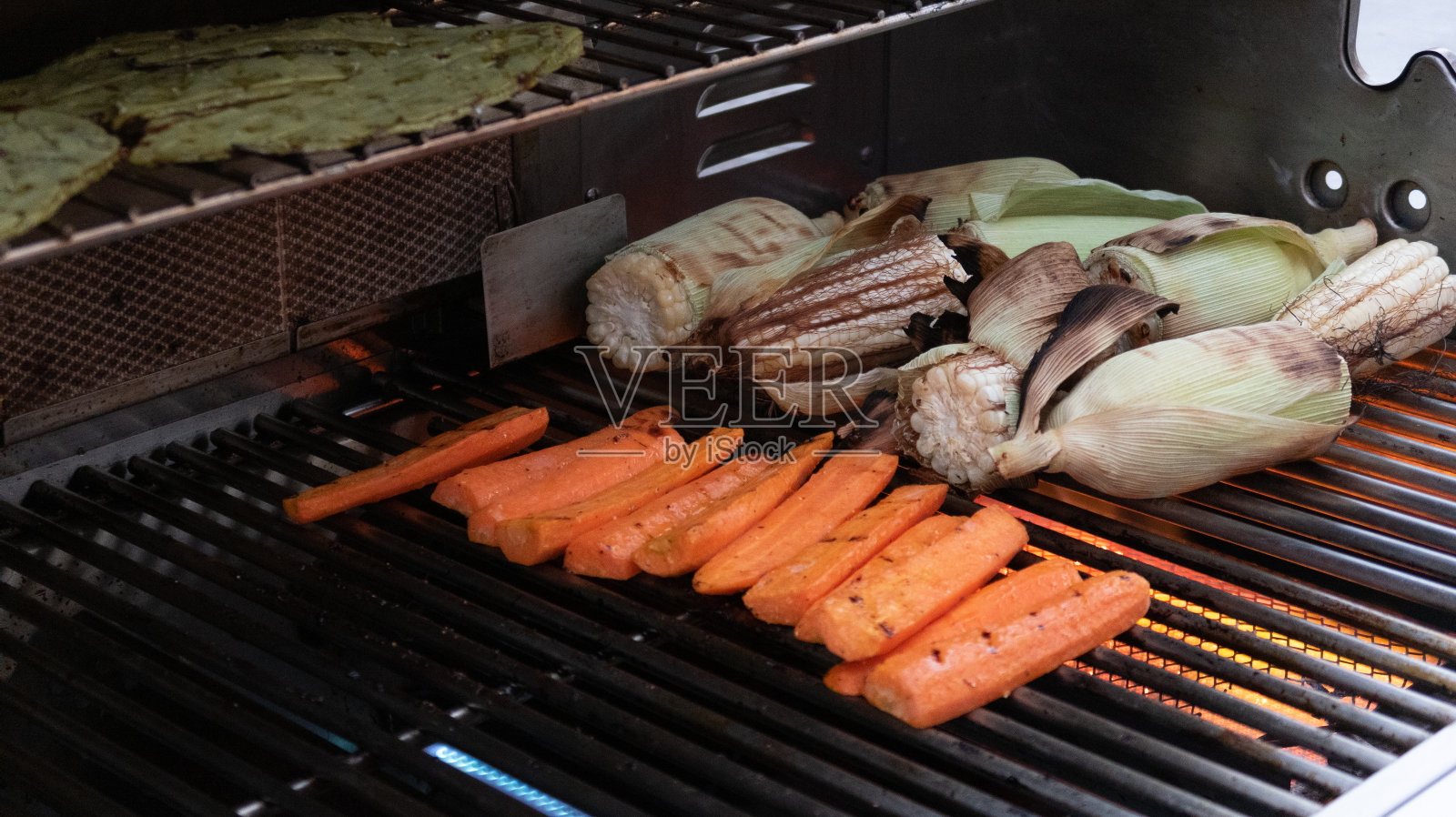 烤架上的胡萝卜和玉米的特写照片摄影图片