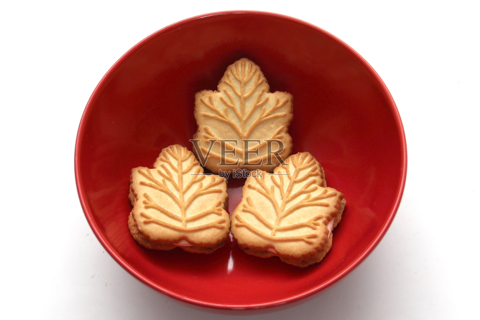 美味的饼干，里面有香草奶油，用蜂蜜或加拿大枫树糖浆制成，这是加拿大的传统甜点，在一个红色的心形碗里照片摄影图片