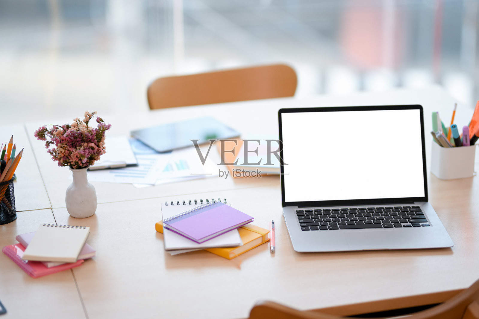 共享工作空间，桌上有便携式笔记本电脑和配件。照片摄影图片