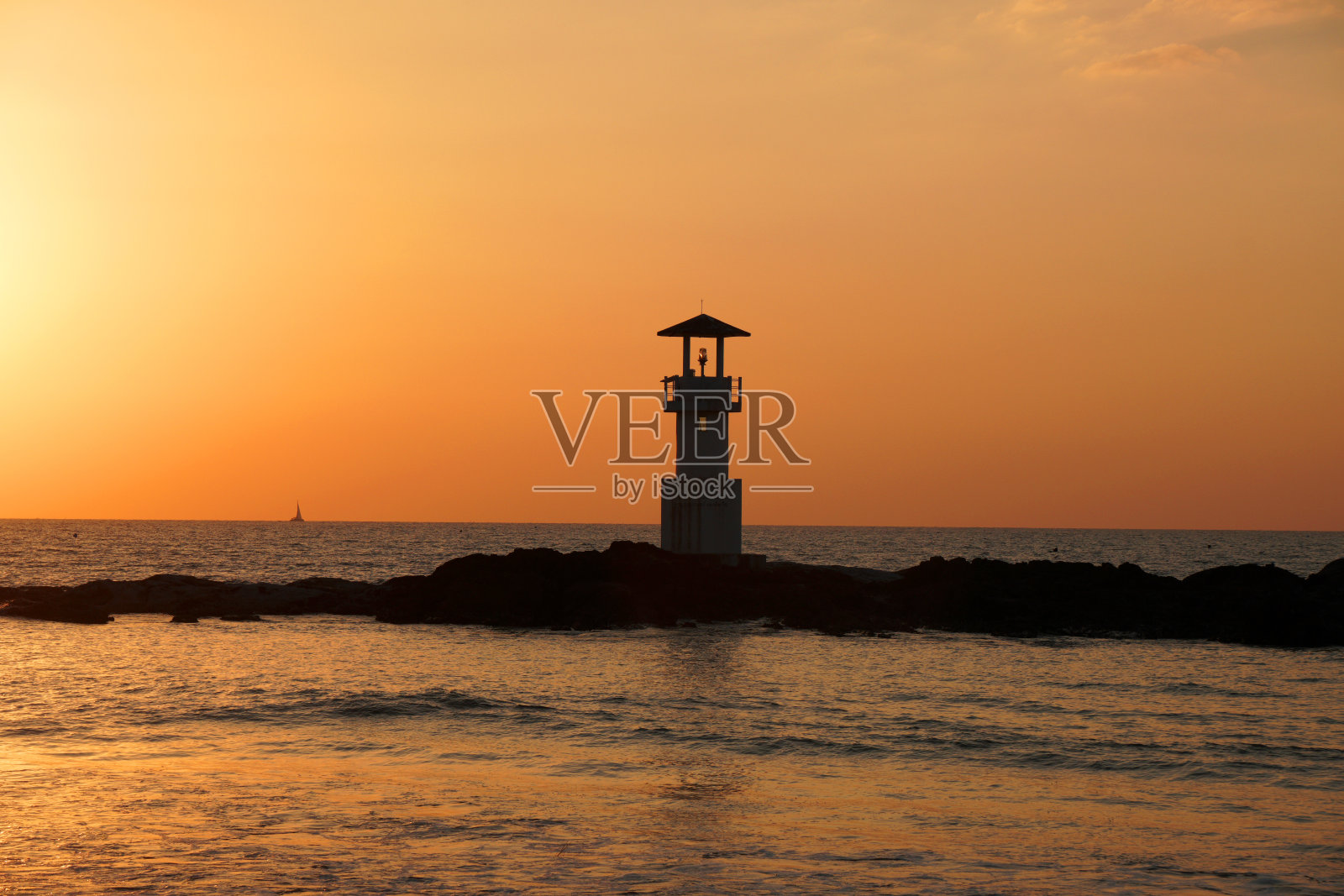 在泰国考拉邦雅的Nang Thong海滩，在岩石上的剪影灯塔，欣赏自然的日落和红色的黄昏天空。海滩上的海景寒冷的氛围，美丽的天空照片摄影图片